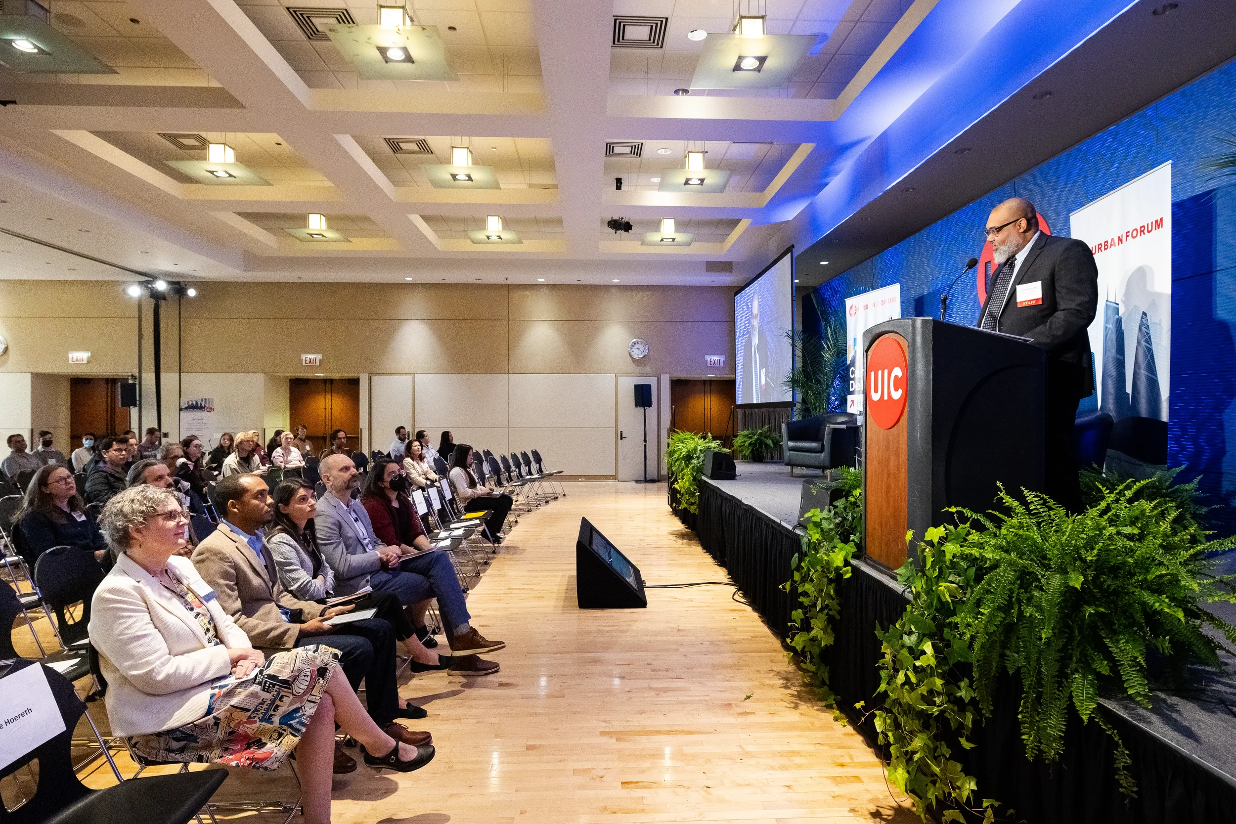 Speaker addresses full seated audience from podium in ballroom at Chicago corporate conference