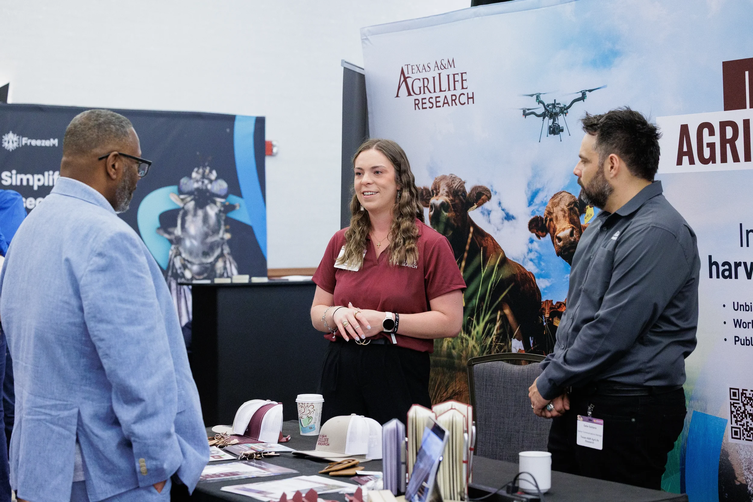 Attendees converse with exhibitor at research booth during Orlando corporate conference