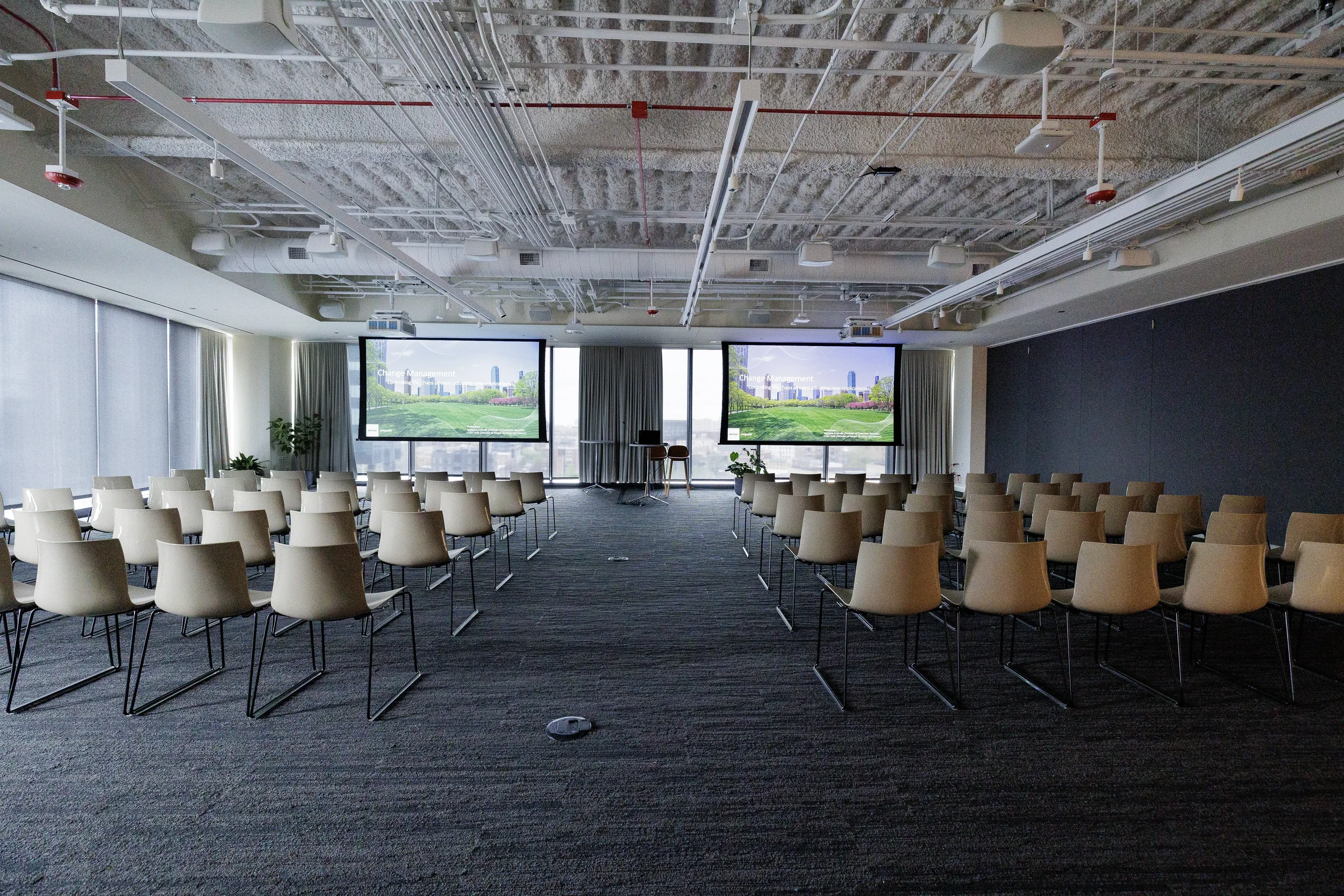 Empty chairs set before dual projection screens in meeting room at Orlando industry conference