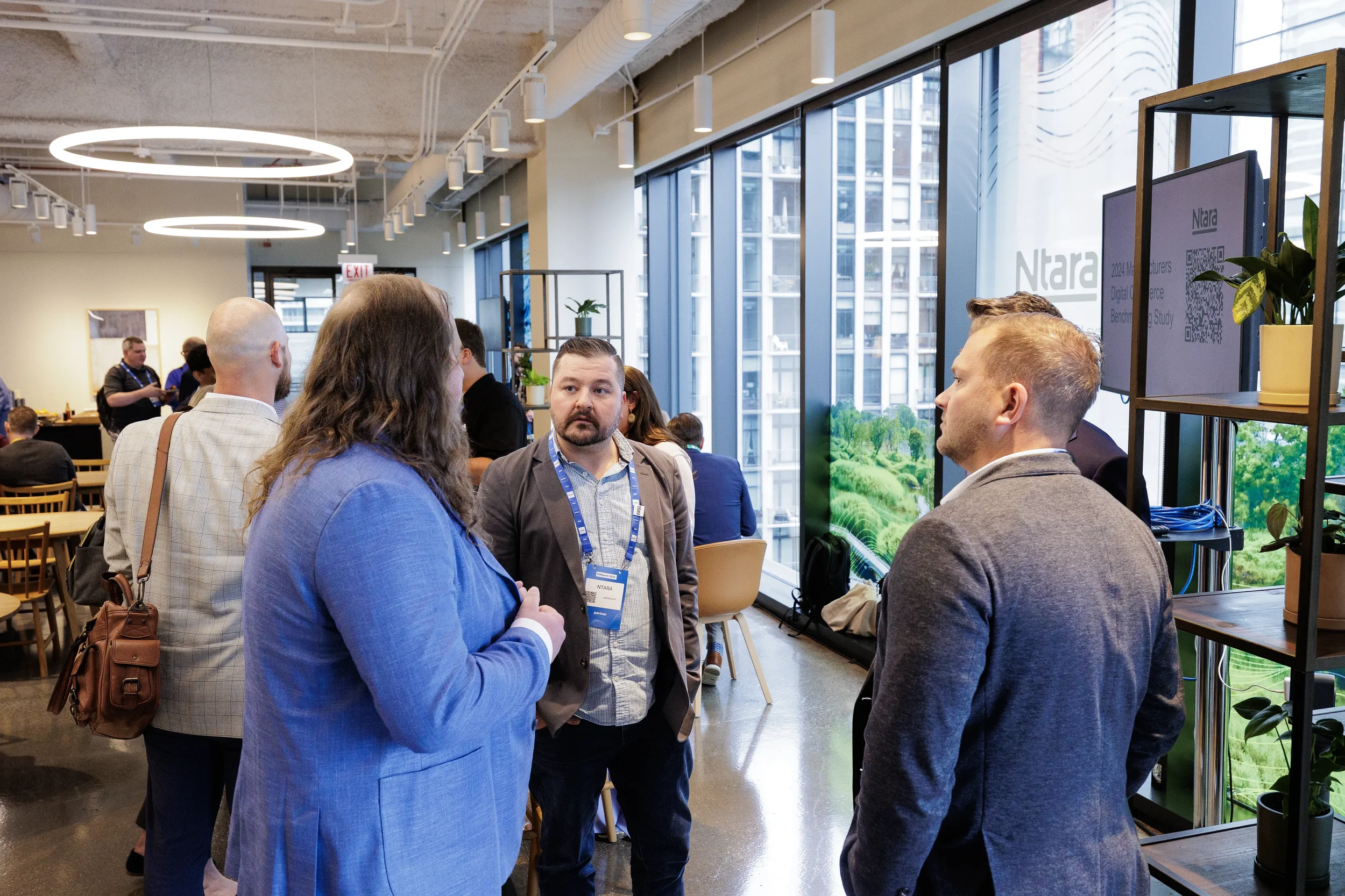 Attendees network in conversation near floor-to-ceiling windows in lounge at Orlando corporate event