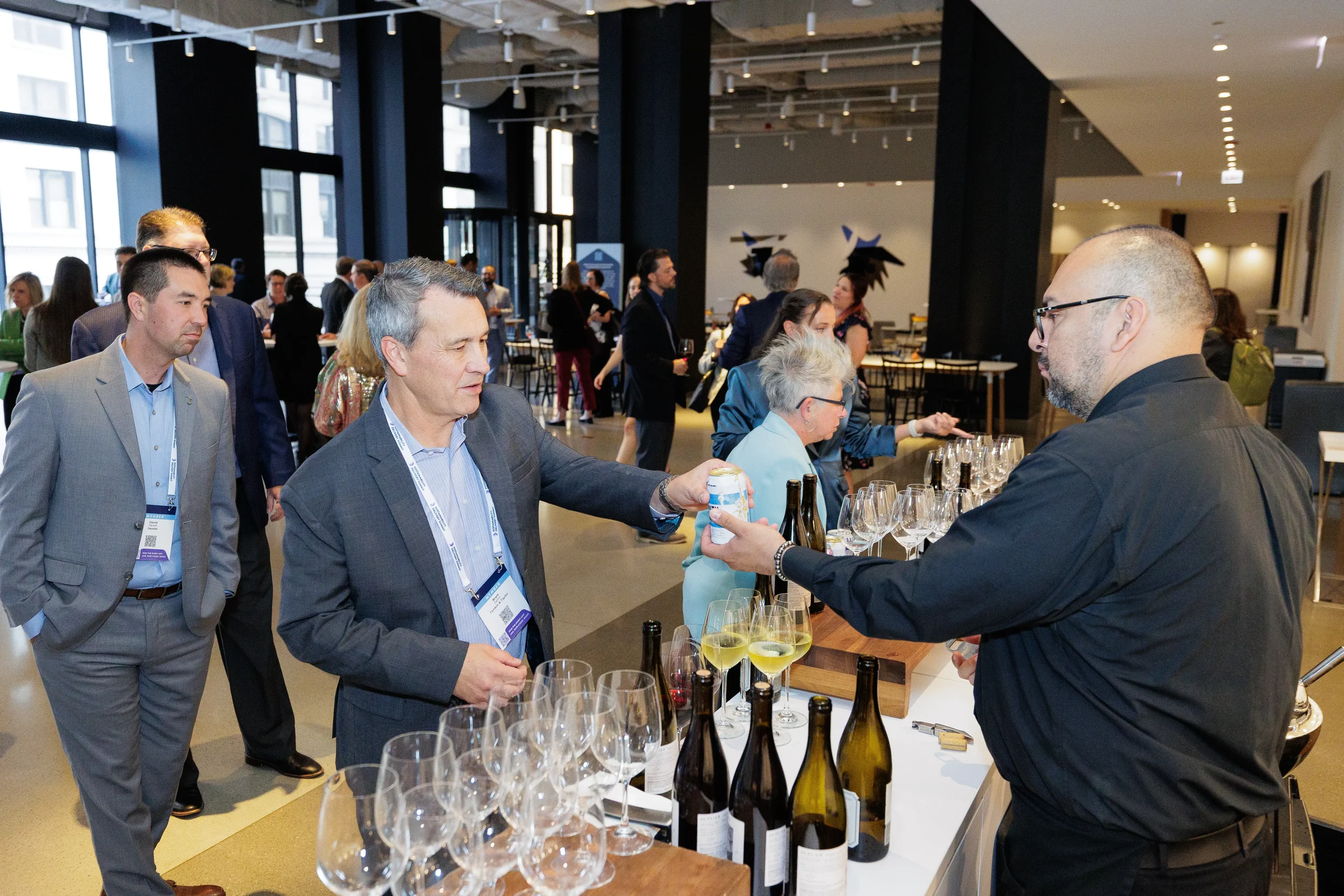 Attendees converse at wine reception bar during evening networking at Orlando industry conference