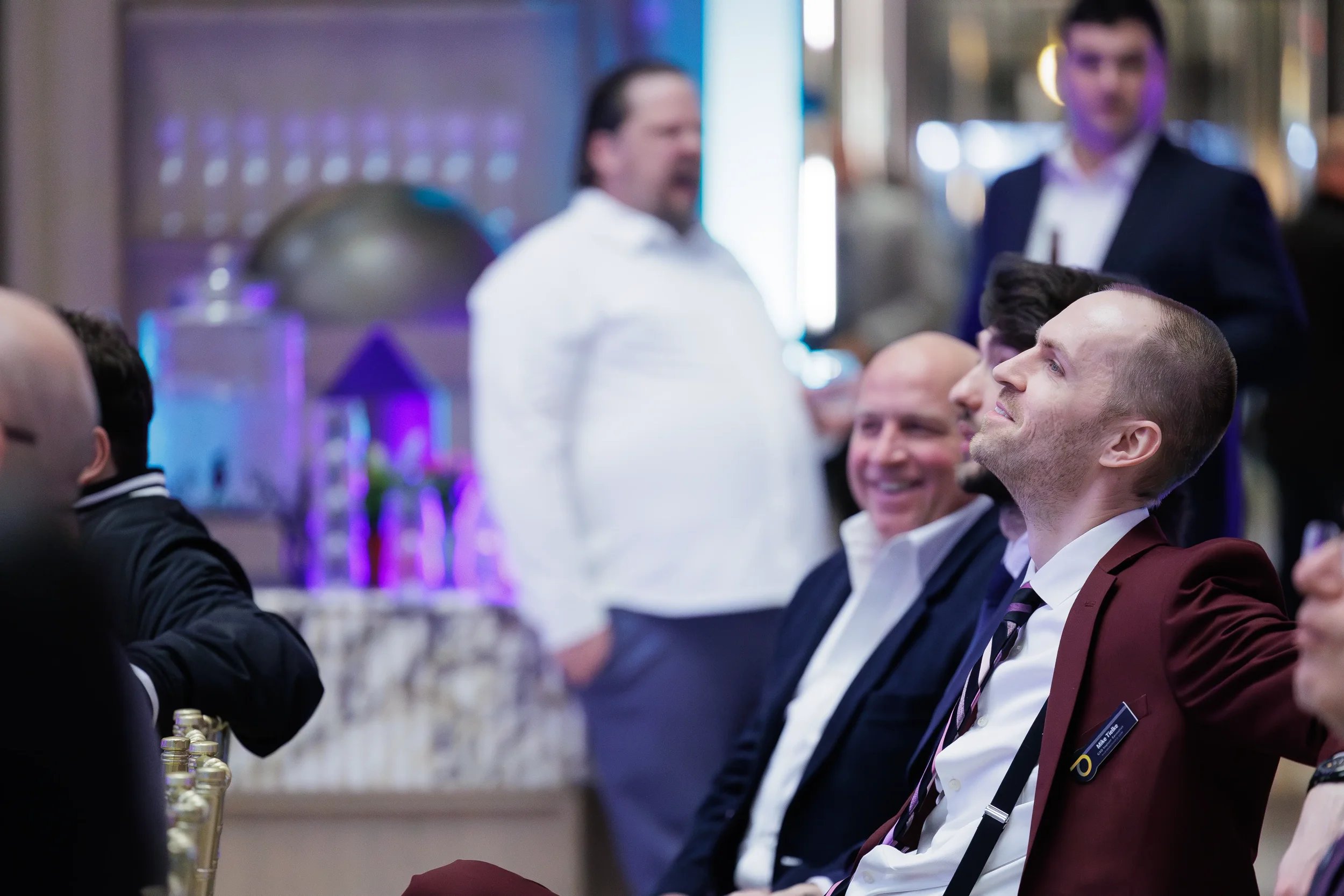 Attendees smile while watching presentation from audience seats at Orlando corporate event