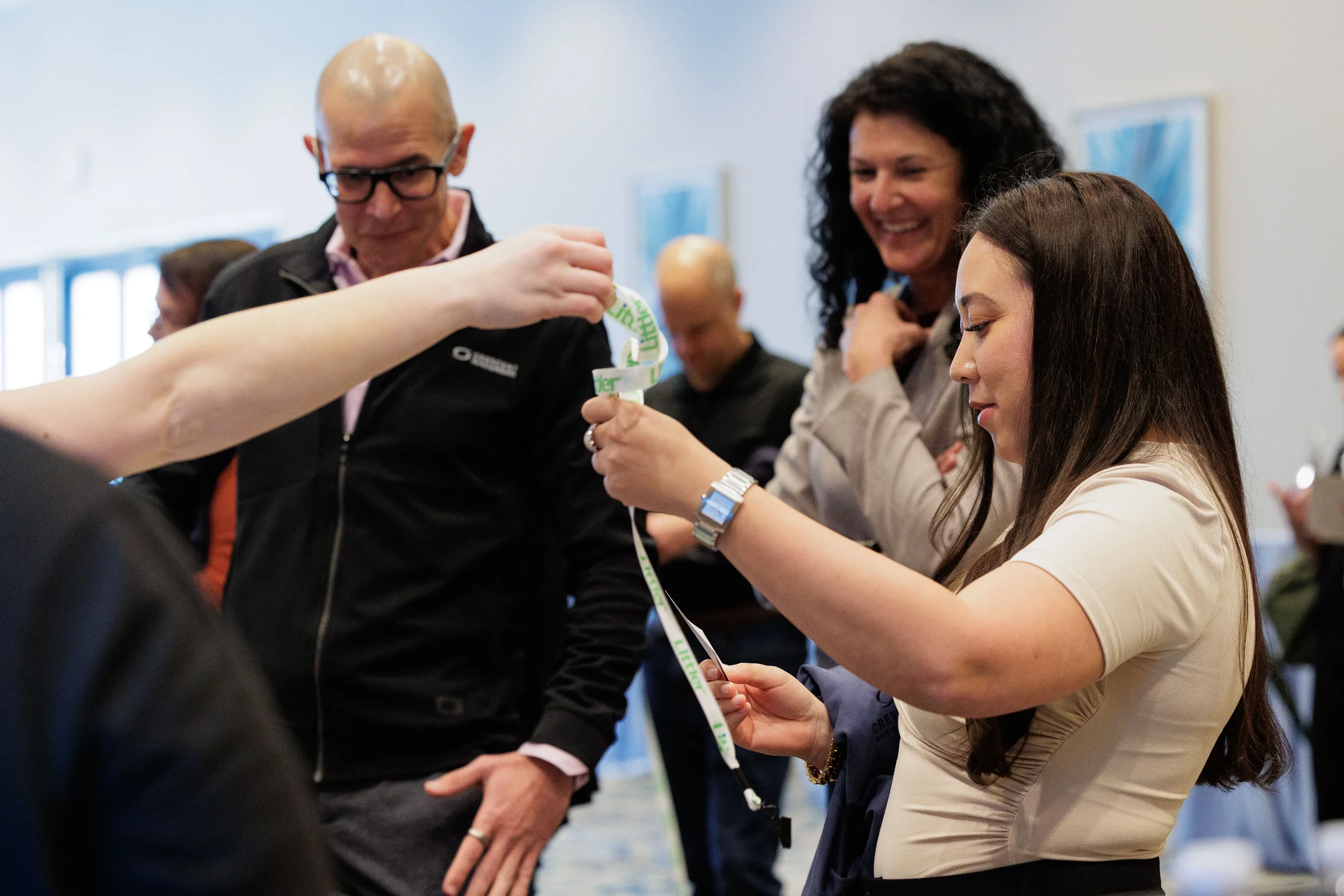 Staff member hands branded lanyard to attendee during registration at Orlando corporate conference arrival