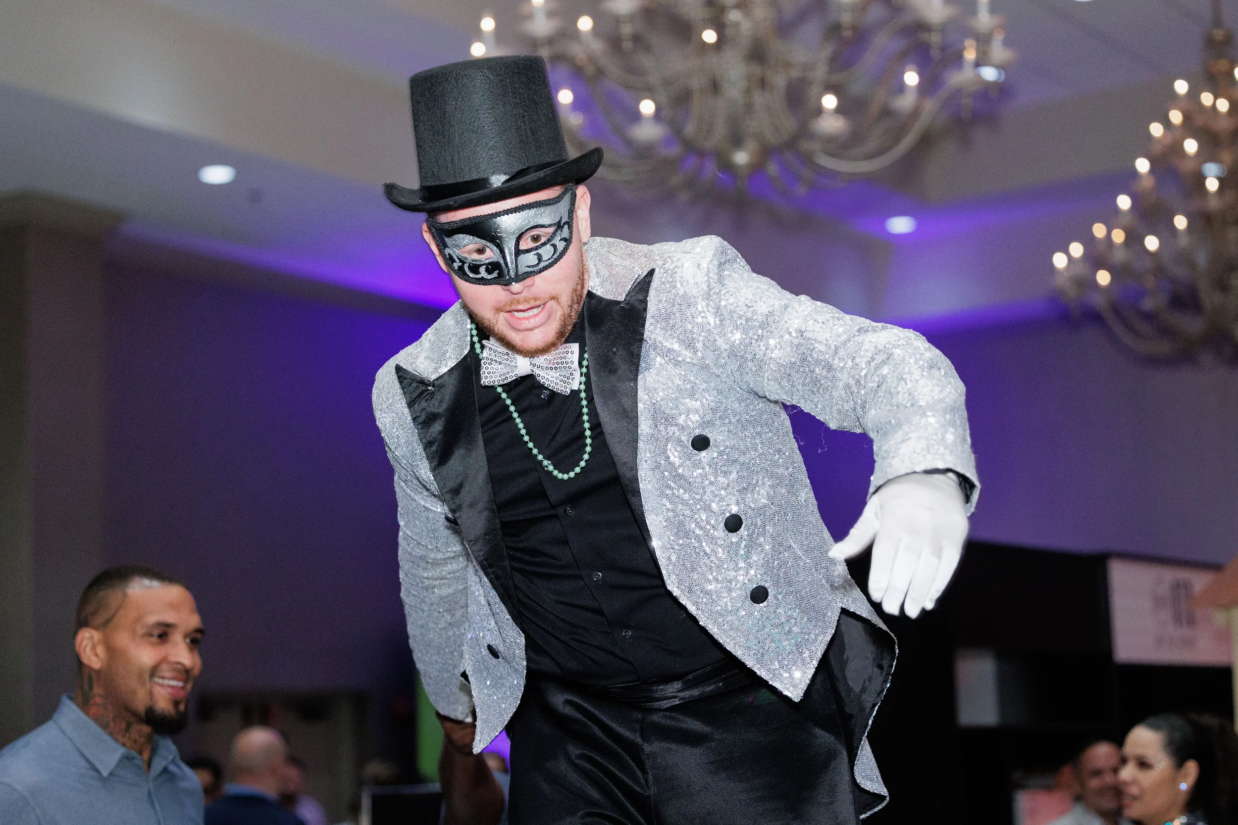 Stilt performer in sequined jacket and masquerade mask entertains crowd at Chicago corporate event