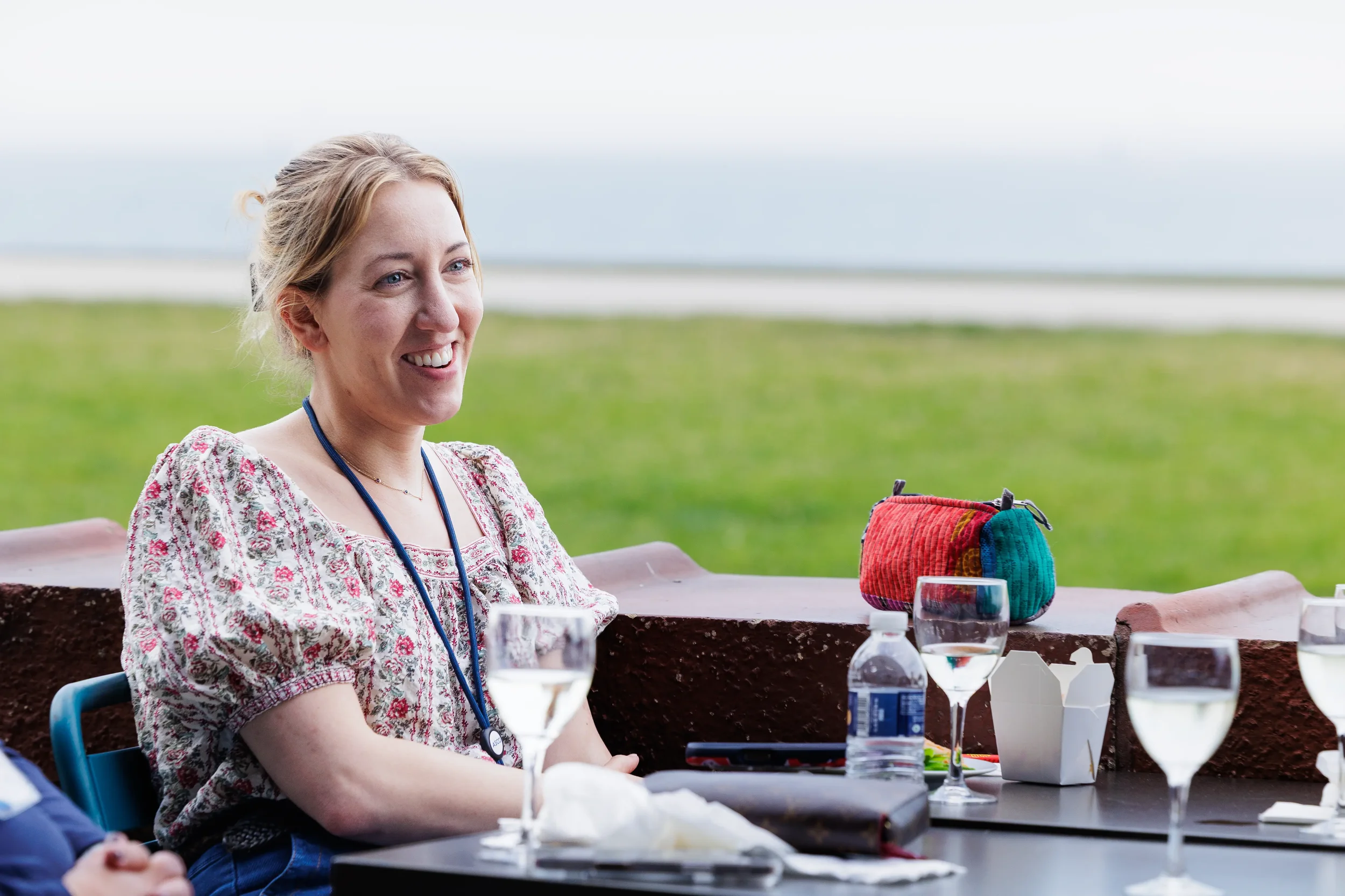 Attendee smiles at table with drinks during Chicago outdoor event reception