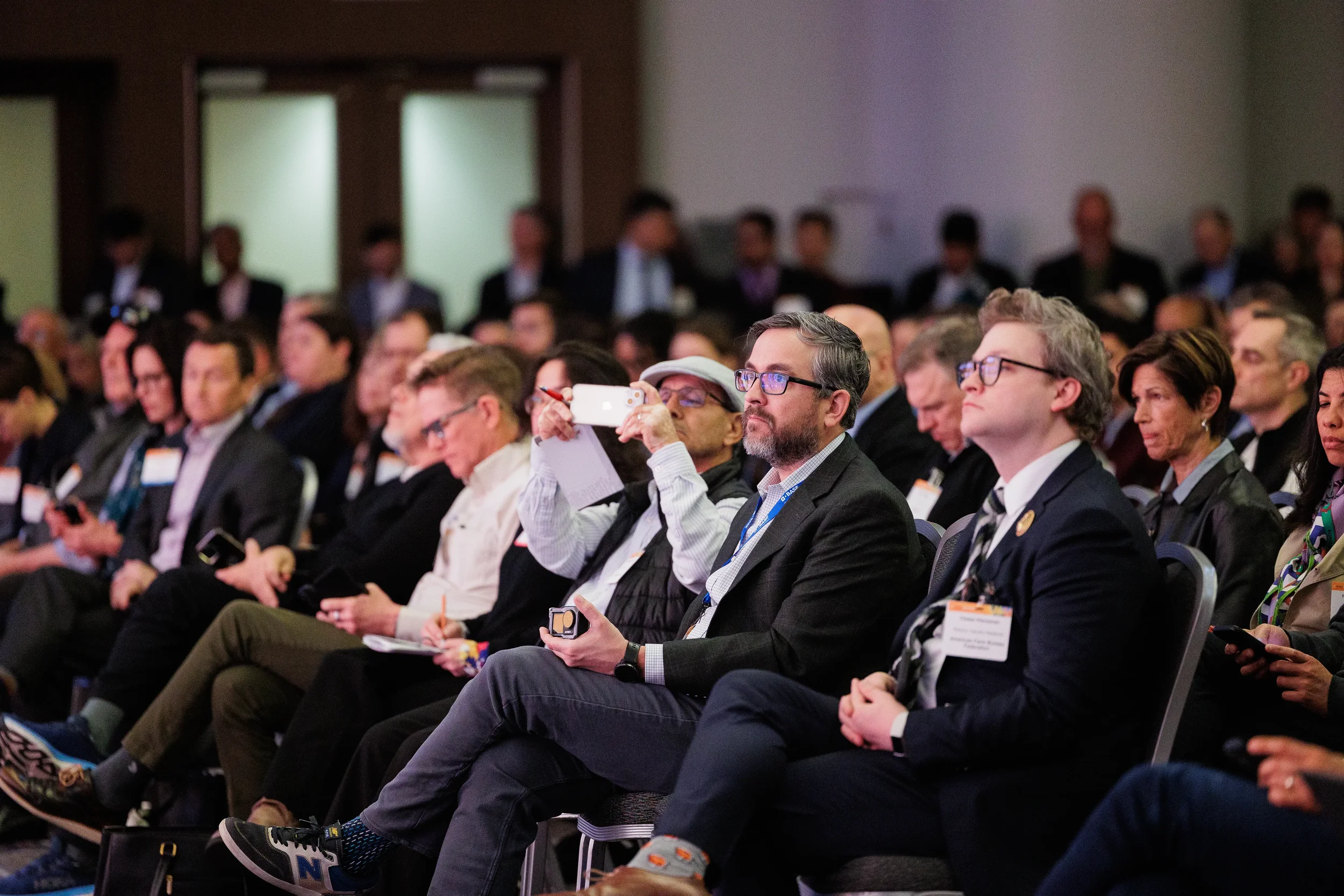 Attendee photographs presentation from seated audience during Chicago corporate conference session