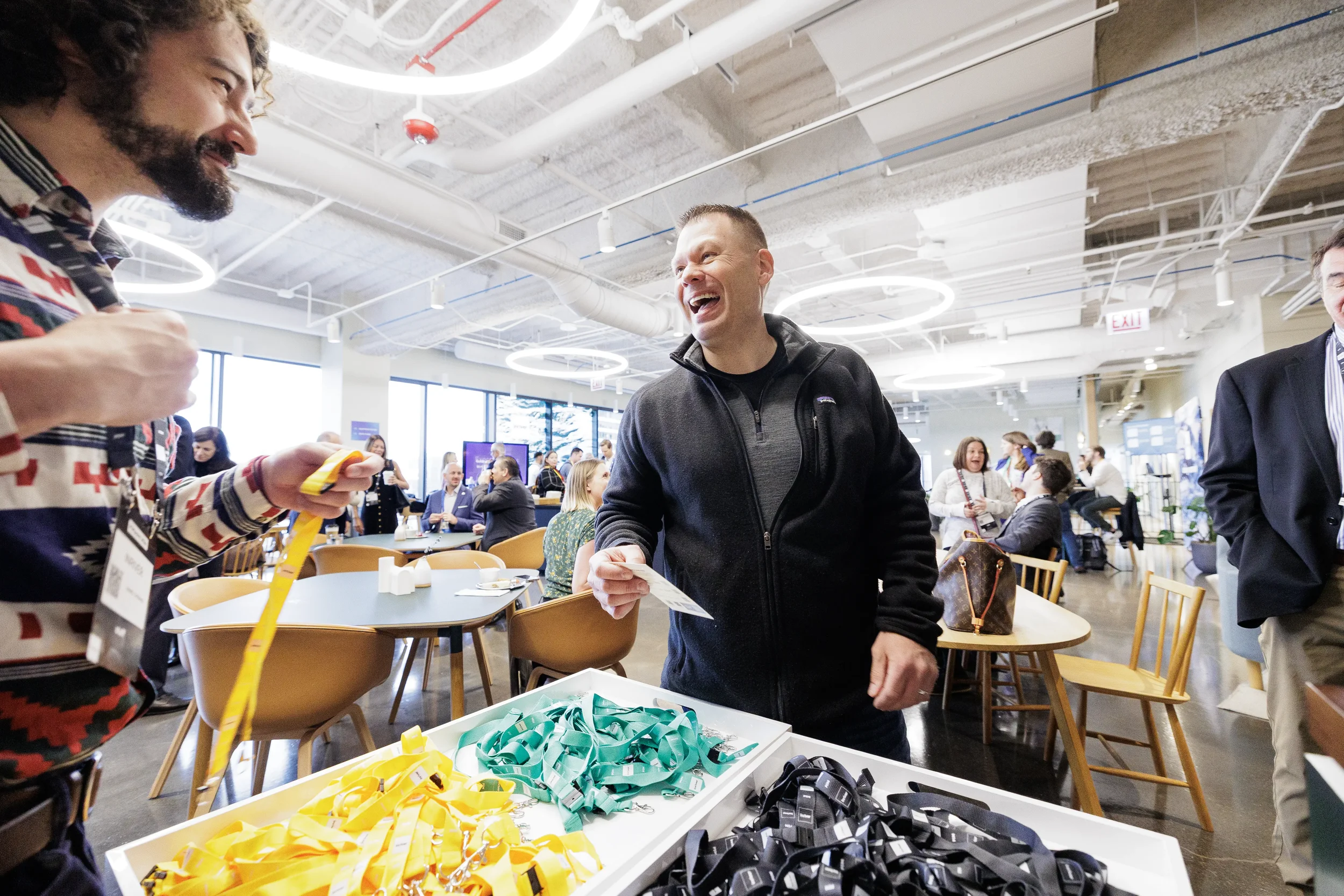Attendee laughs while picking up lanyard at registration table during Chicago corporate event