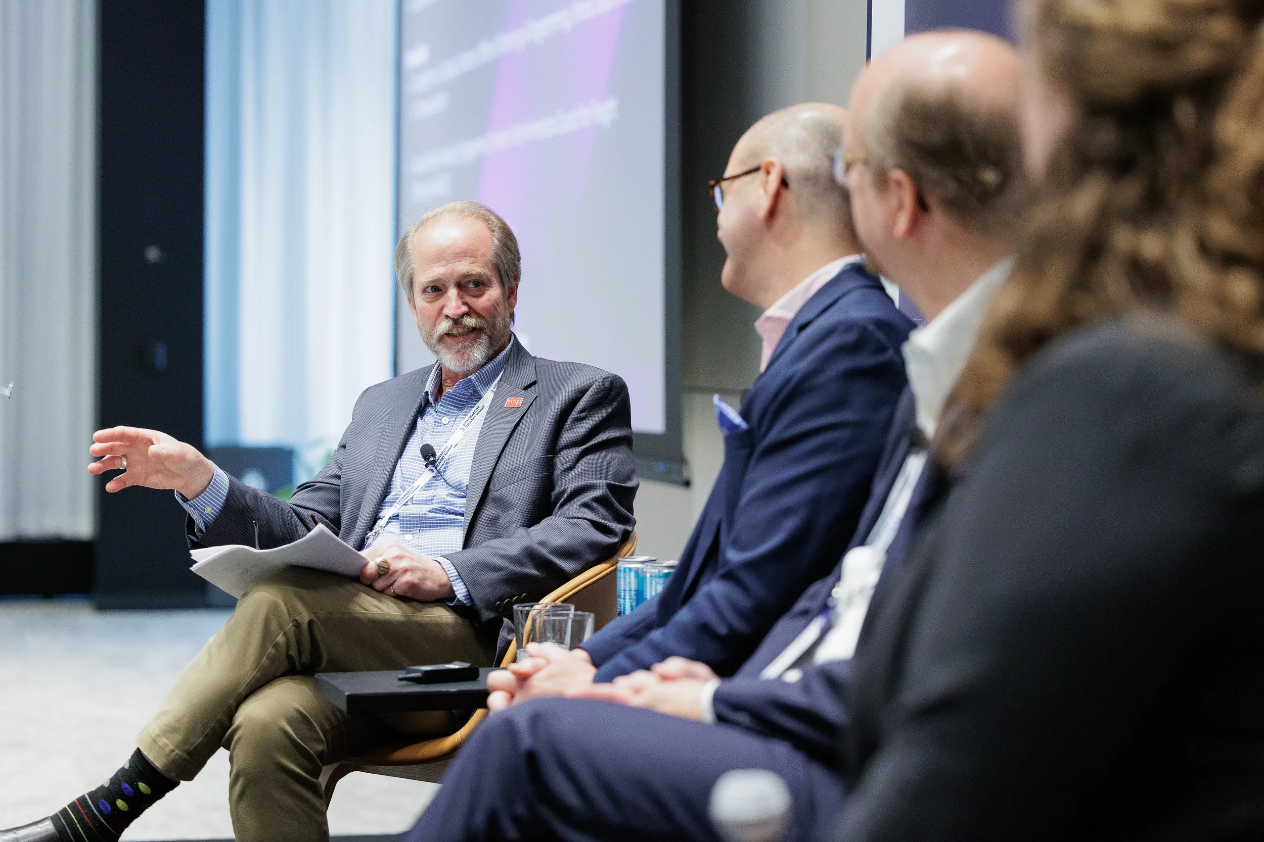 Panelist gestures while speaking during seated discussion at Orlando industry conference