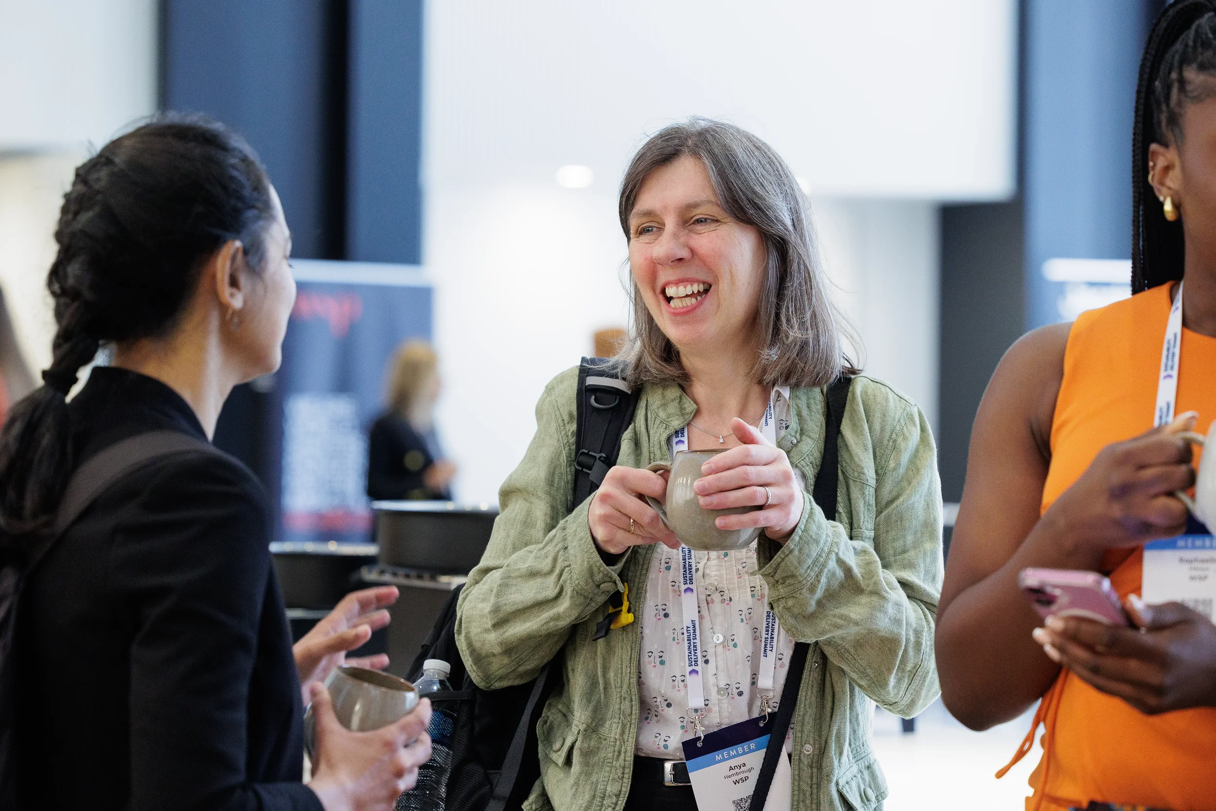Three attendees laugh and converse in lobby during Chicago corporate conference event