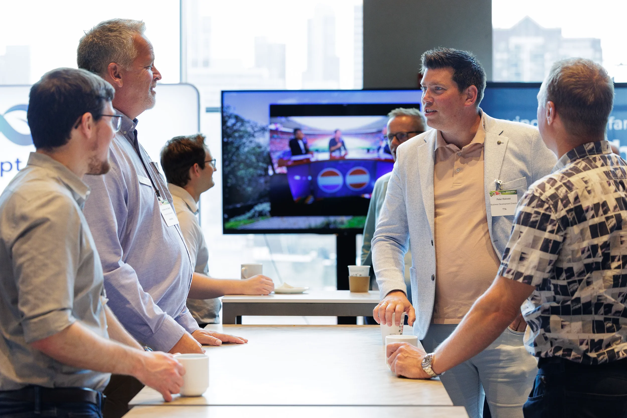 Attendees converse over coffee at standing table during networking break at Orlando industry conference