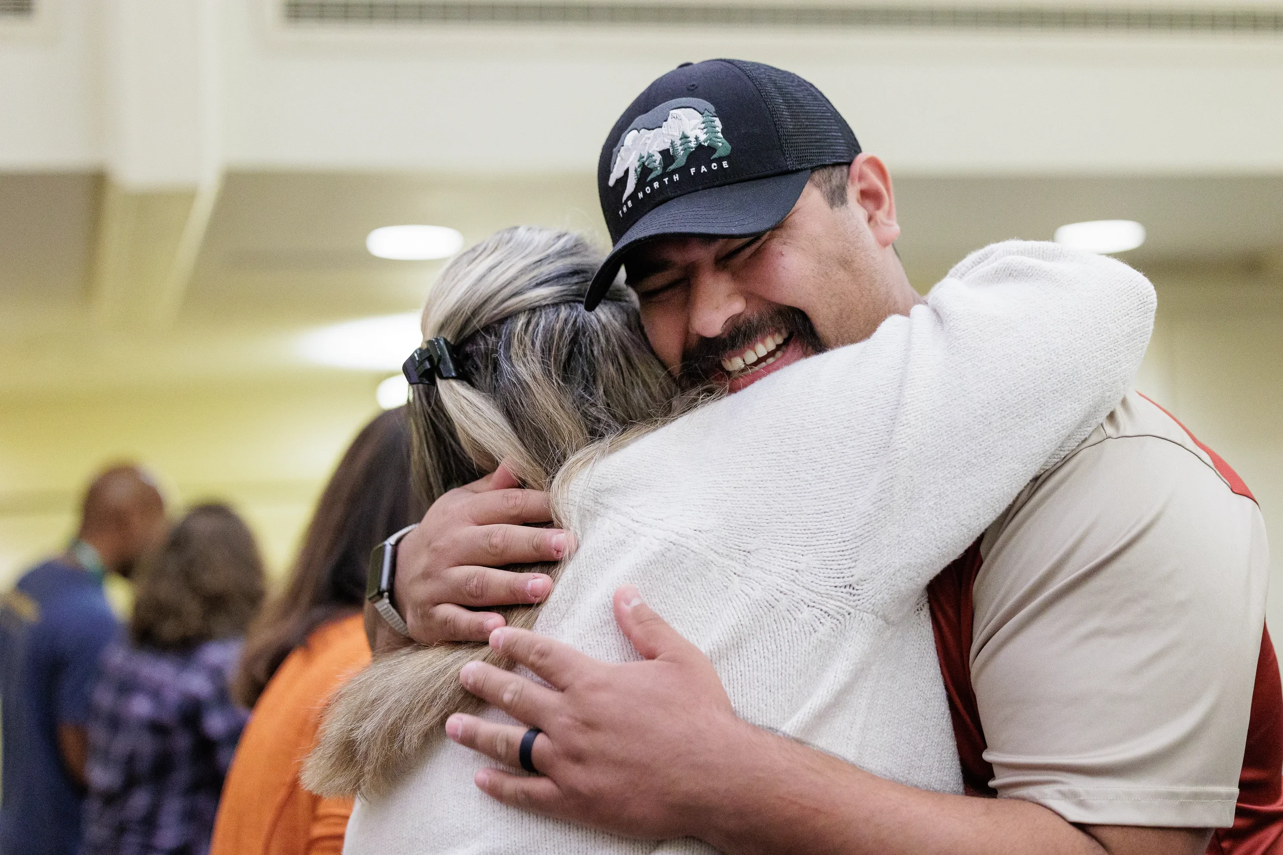 Two attendees share a warm embrace during gathering at Chicago conference