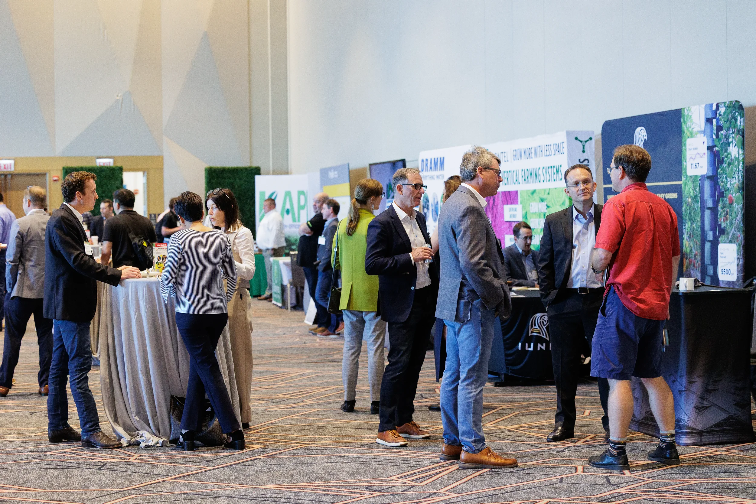 Attendees converse among exhibitor booths on expo floor at Orlando industry conference event