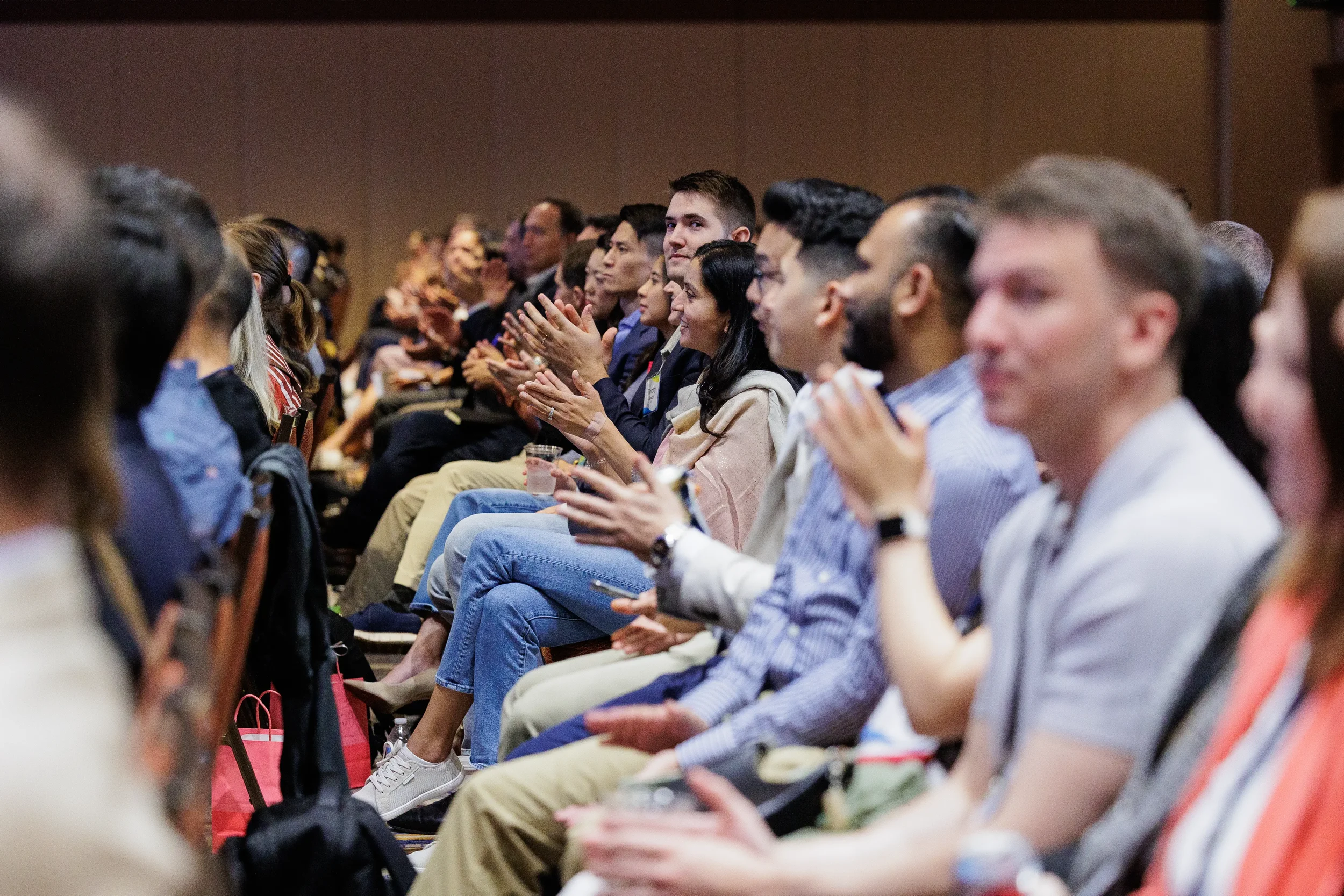 Audience applauds while seated during session at Orlando industry conference