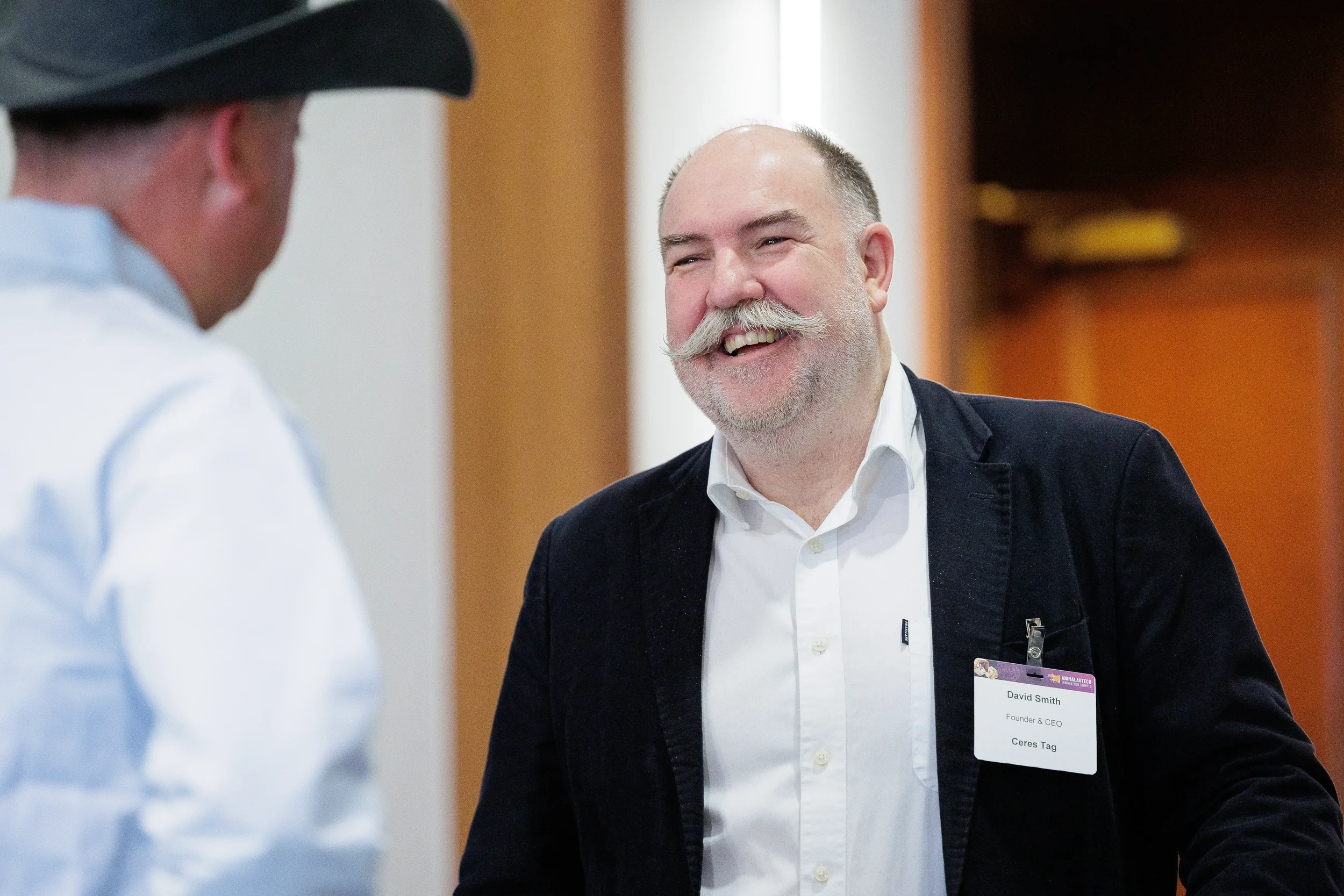 Attendees share a laugh during conversation in hallway at Orlando corporate conference