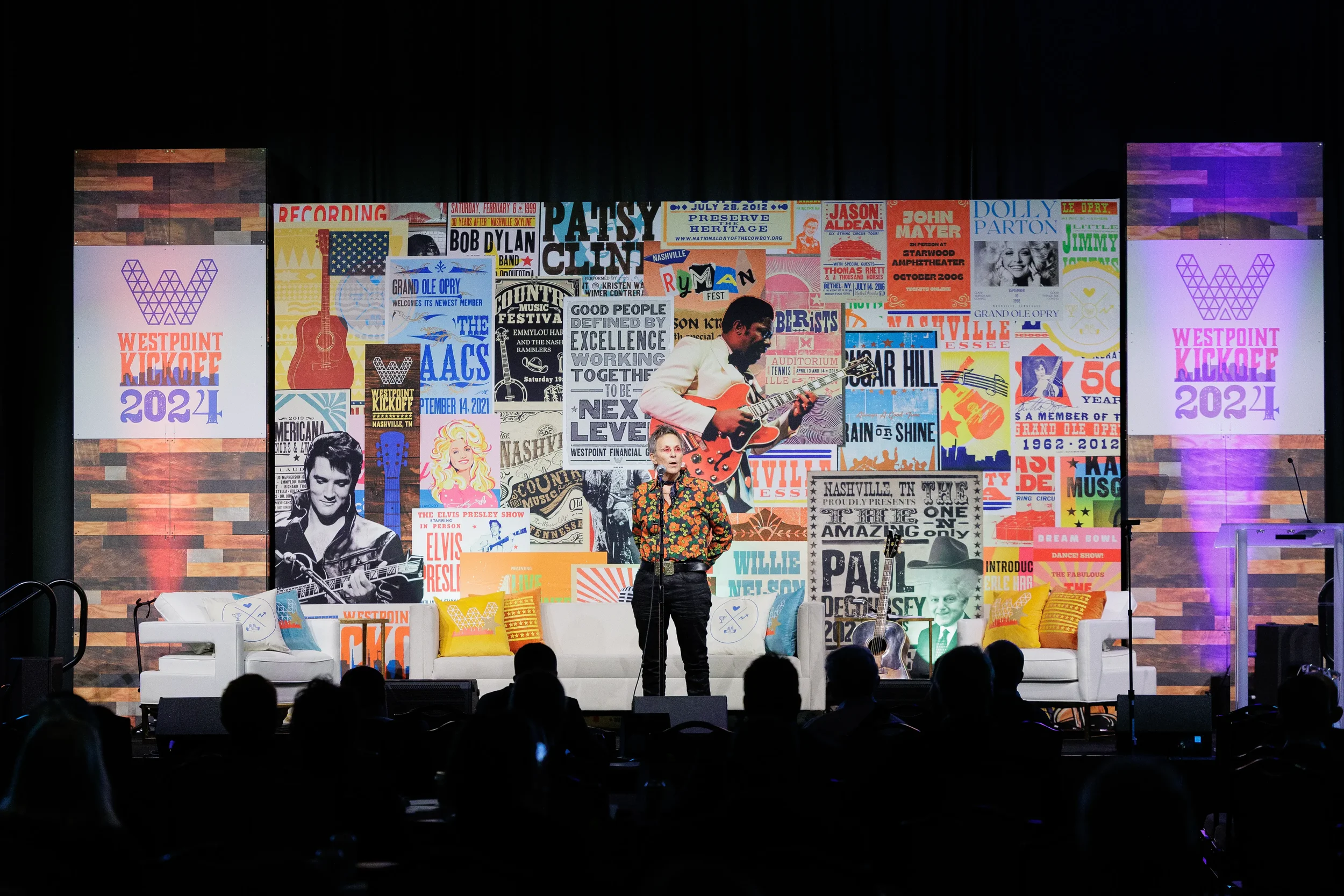 Live musician performs on stage in front of colorful branded backdrop at Chicago corporate conference event