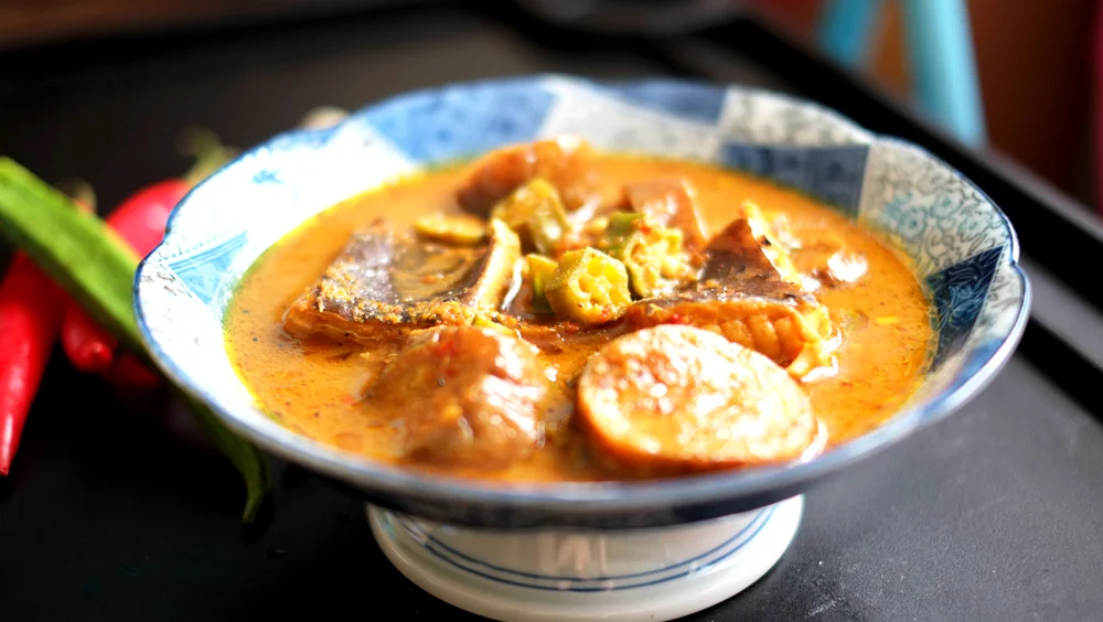 Nyonya Kuah Lada Prep time: 20 mins Cook time: 30 mins Total time: 50 mins Serves: 6 Ingredients: · 2 medium-sized pieces of Stingray/Skate (cut into chunks) · 1 eggplant · 6 strips of Okra · 2 strips of Lemongrass · 3/4 cup of Tamarind flesh/pulp For the paste or Rempah · 15 Shallots (peeled) · 1 small piece of Blue Ginger · 2 small pieces of Yellow Ginger Instructions: 1) First, prepare the paste (or Rempah) by roughly cutting up the chillies, blue ginger and yellow ginger into smaller pieces, and tossing these into a blender with the shallots, pepper seeds and shrimp paste. Blend it until you get a paste-like consistency. 2) Set the Rempah aside, we will only need it after the other ingredients are all prepared. 3) Next, pound the lemongrass stalks. It would be best if you had a mortar and pestle you could work in, but if you don't have one of those in the kitchen, simply pounding with the back of your knife works fine as well. 4) Time now to work on the Tamarind/Assam water, squeeze the tamarind pulp over a bowl until the juices run, after which pour 2 cups of water in with the juices and mix. Set this aside. 5) Grab the eggplant and Okra and start slicing them up. 6) Rub salt over the stingray pieces, and set them aside. 7) Heat up 2 tablespoons of vegetable oil in a wok until hot. 8) Gently spoon in the paste and stir it around in the oil until it is fragrant (about 2-3 minutes). 9) Next, throw in the stingray, eggplant and okra and give it a good toss-about until they are all generously coated with the paste. 10) Add in your Tamarind water and when it comes to a boil, lower the fire and allow to simmer until the eggplant and okra are soft, and the stingray is cooked through. 11) Taste the gravy, and add sugar to balance out the sourness of it (roughly about 1-1 1/2 tablespoons). Remember, DO NOT ADD SALT! 12) Serve the Kuah Lada with jasmine rice.