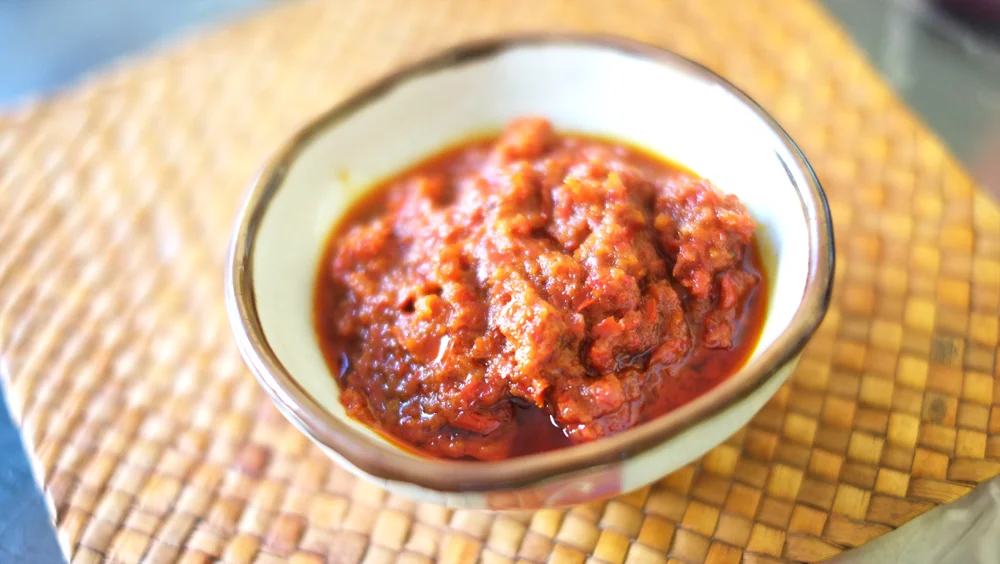 Sambal Belacan Prep time: 15 mins Cook time: 25 mins Total time: 40 mins Ingredients: · 20 Fresh Chillies · 6 Candlenuts/Buah Keras · 30g Belacan/Shrimp Paste · 4 Garlic cloves · 1/2 stick of Lemongrass · 50g Tamarind Pulp · 2 tablespoons Vegetable oil Instructions: 1) Prepare the Sambal paste: remove the seeds of the fresh chillies and cut into inch-long pieces. Cut up the Candlenut (Buah Keras), Belacan (shrimp paste) and garlic cloves into small pieces as well. 2) Throw all the ingredients into a blender and blend into a paste. 3) Pound the Lemongrass to release its (wonderful!) fragrance. 4) Mix the tamarind pulp with 1 cup of water, remove sediments and set aside. 5) Heat up a wok or large skillet with the vegetable oil (I used Canola) and when the oil is hot enough (you should see bubbles), add the sambal paste and fry. 6) Throw the Lemongrass in to mix with the paste. 7) Let the Sambal cook for 10-12 minutes, consistently stirring it. 8) At this point, add the tamarind water and mix well with the paste. 9) Let it cook for another 10 minutes, add sugar by the teaspoon-full and taste after every one is added to tweak to your preferred level of sweetness before turning off the fire, and there you have it, you have just made your own homemade Sambal Belacan! Enjoy it!
