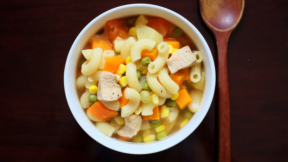 Vegetable and Chicken Pasta Soup Prep time: 15 mins Cook time: 3 hours Total time: 3 hours 15 mins Serves: 4 Ingredients: · 1 large Carrot · 1 cup Green Peas · 1 cup Corn · 1 medium Potato · 4 cloves of Garlic · 200g Chicken Breast (leave out for vegetarian version) · 4 cups Chicken/Vegetable Broth · 2 cups Elbow Pasta · 1 teaspoon Salt · 1 teaspoon Thyme Instructions: 1) Dice the carrot and potato, remove the skin of the garlic cloves and set aside. 2) Cut the chicken breast into cubes and season with 1 teaspoon of salt. 3) In a large slow cooker or rice cooker pot, throw in the carrots, peas, corn, potatoes, garlic and chicken breast. 4) Season with a pinch of salt and a dash of black pepper. 5) Add the thyme and chicken/vegetable broth. 6) Set your slow cooker on medium and leave to cook for 6-8 hours, if you are using a rice cooker to cook the soup, set it to cook for at least an hour. - To cook this vegetable and chicken soup on a stove, add all the ingredients in a large pot and bring to a boil, after which lower the fire to allow it to simmer for 45 minutes. 7) Cook the pasta according to package instructions and serve the dish with the soup poured over the cooked pasta in a serving bowl. 8) Serve hot!