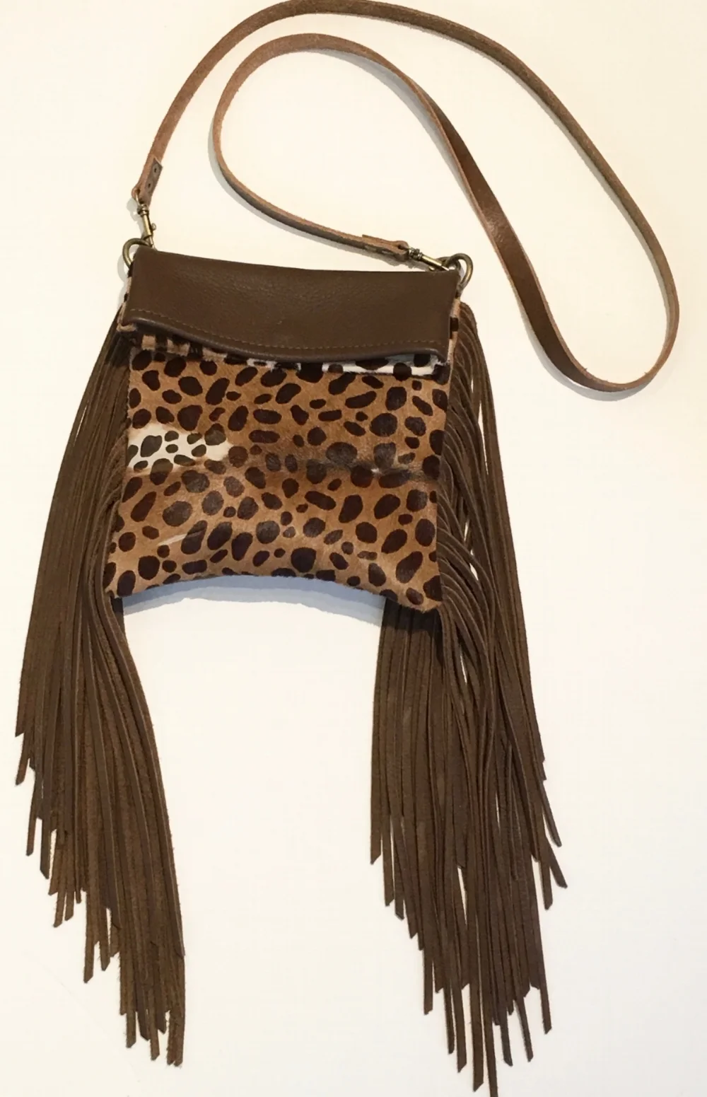Reversible one side soft brown deerskin, the other hair on hide Handbag with long strap. Lambskin fringe and magnet closure. $380., .jpg