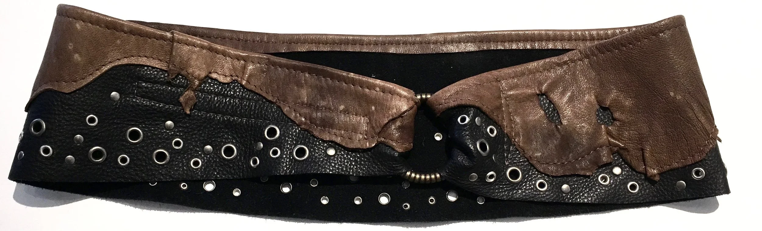Black cowhide with brown overlay embellished with antiqued nickel metal work. Brass ring with adjustable velcro closure. $278..jpg