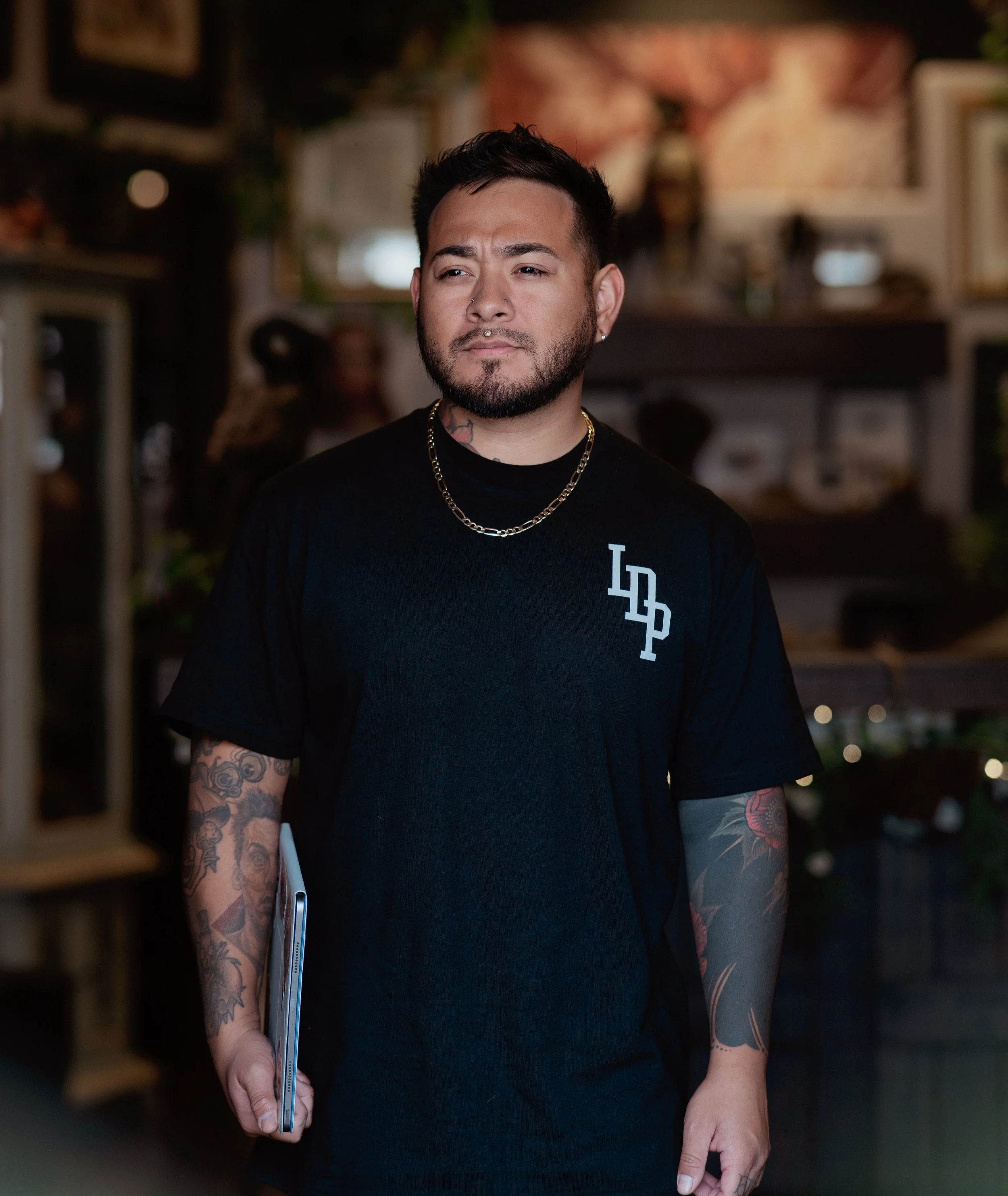 Tattooer holding ipad, ready to create new designs.