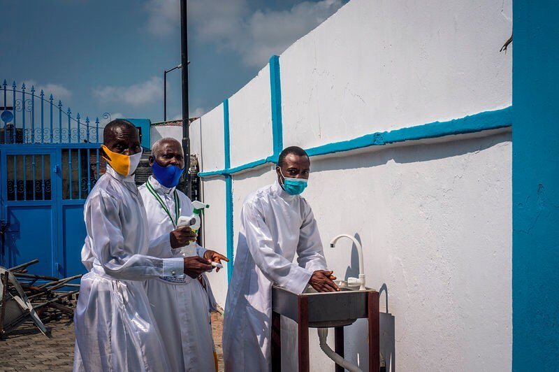 At the Celestial Church of Christ, church leaders guide a member to a handwashing station. When churches reopened earlier this year as Nigeria entered a new phase in its lockdown, they were instructed to provide worshippers with hand sanitizers and t