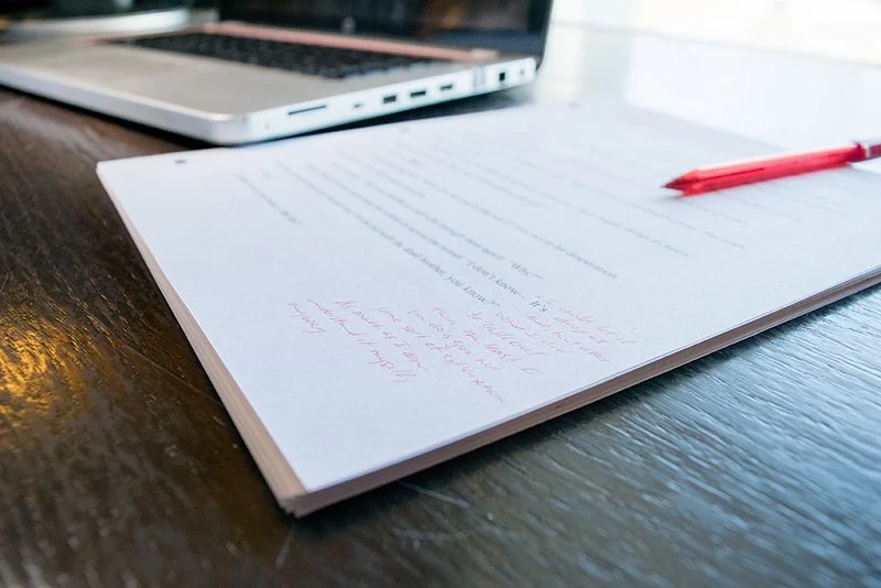 An edited page with red markup showing the work of an expert editor