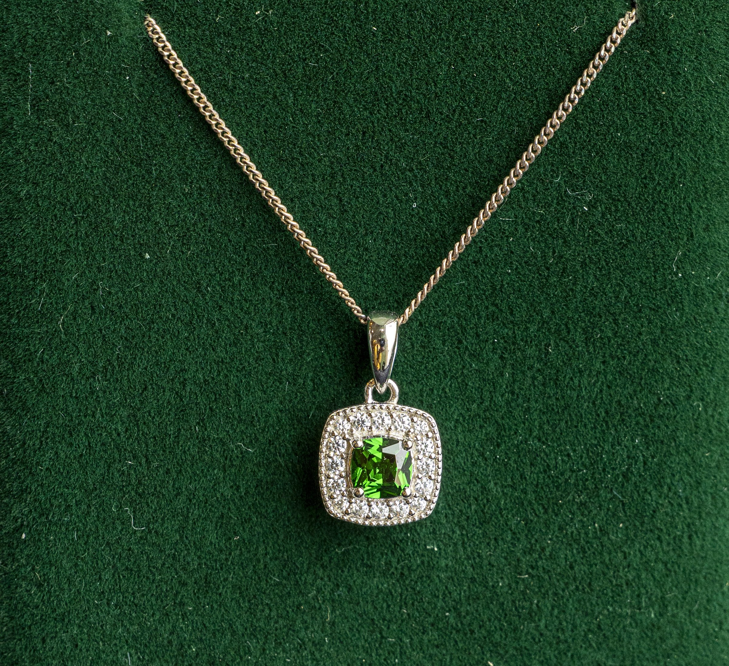 Sterling silver Celtic pendant necklace featuring a square-cut green emerald gemstone surrounded by cubic zirconia.