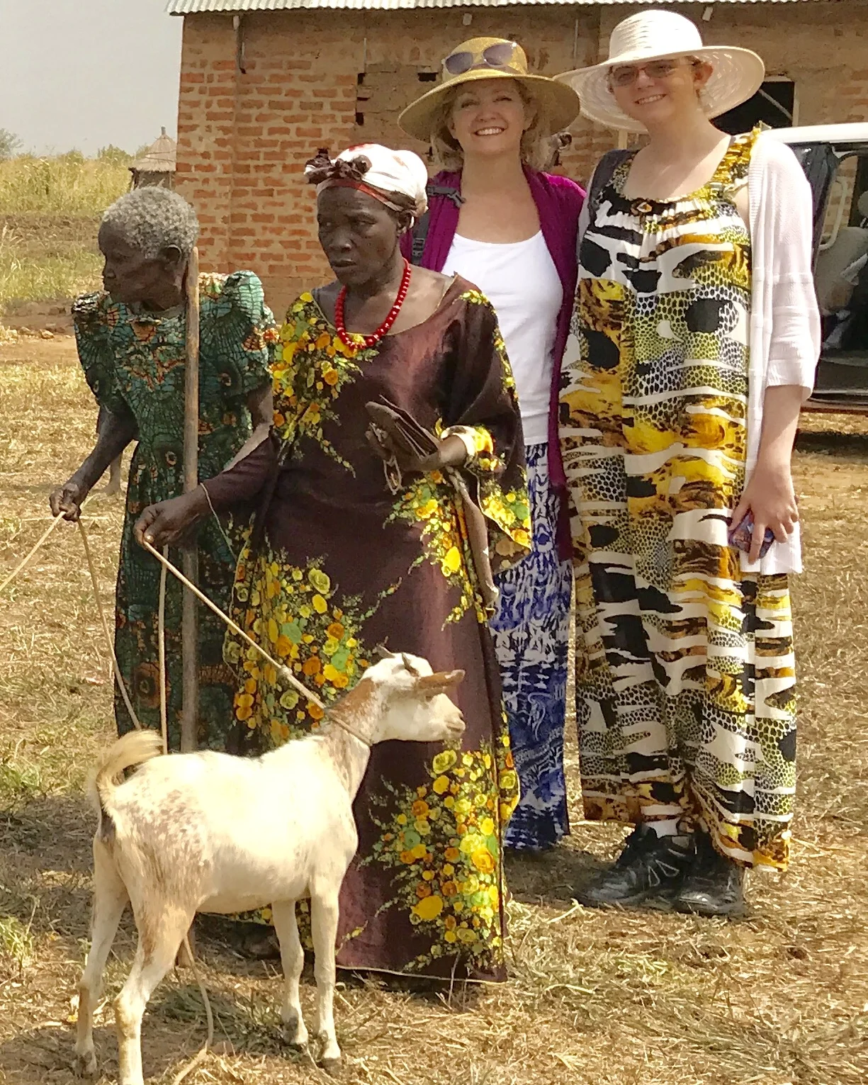 Tobi (middle right) and her daughter (right) posing with new beneficiaries and their goats.