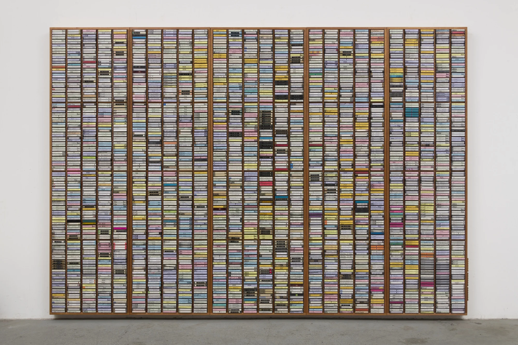 Mark A. Rodriguez, 3rd Gen , 2018, custom CNC-routed mahogany and enamel shelving units; audiocassettes; ink and marker on cassette sleeves; plastic cases, 89.1 × 129.4 × 3 ½ inches (226.3 × 328.6 × 8.9 cm)