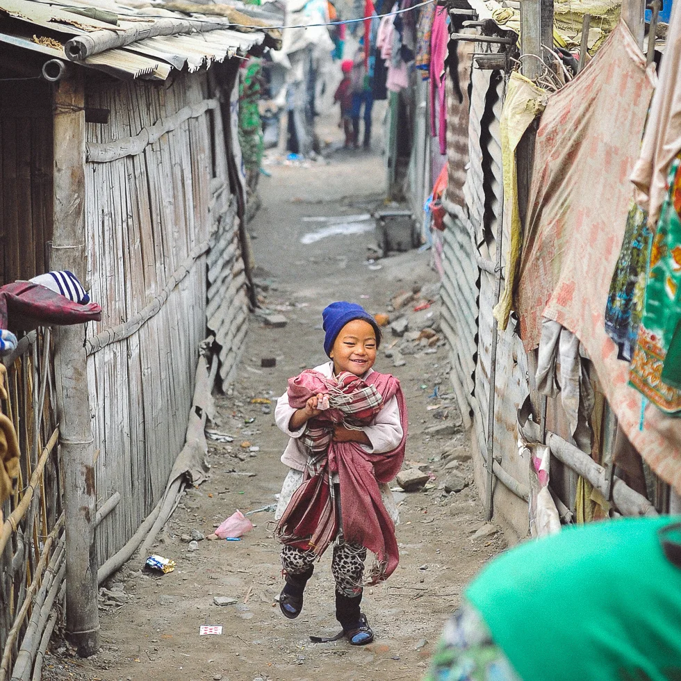 A sweet young girl runs through the homes of Balkhu Slum Settlement in Kathmandu | photo © touchnepal.org