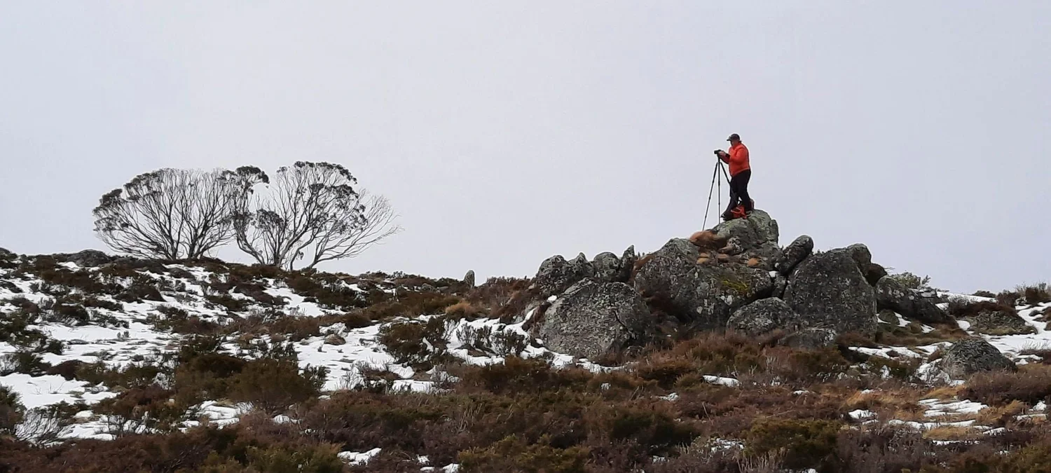 Dani Watson photographing in an alpine landscape