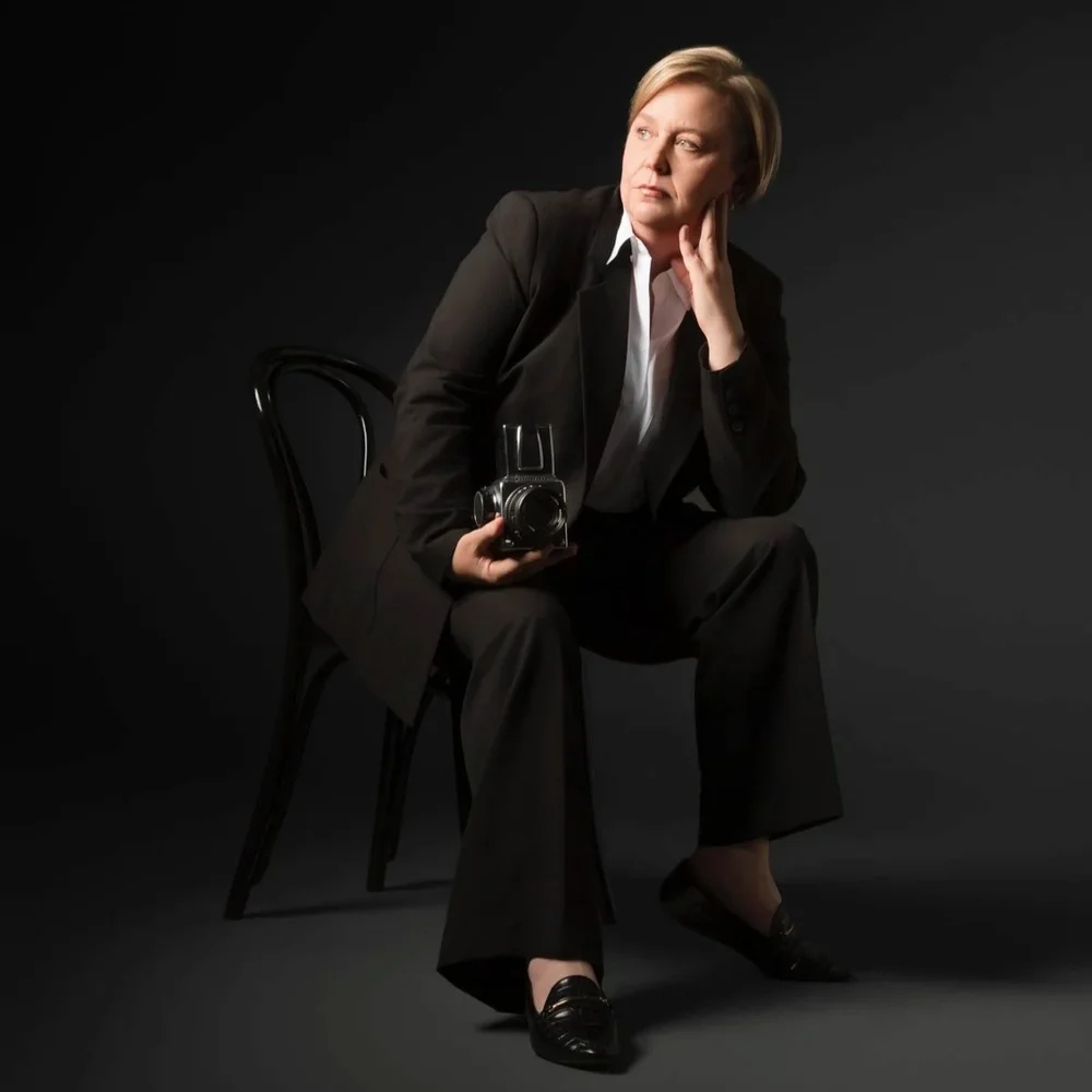 Dani Watson seated with a medium-format camera