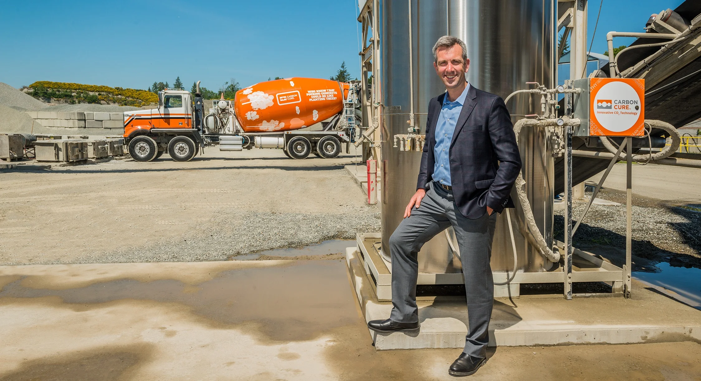 Rob Niven stands before a CarbonCure tank that stores carbon dioxide at a concrete plant.