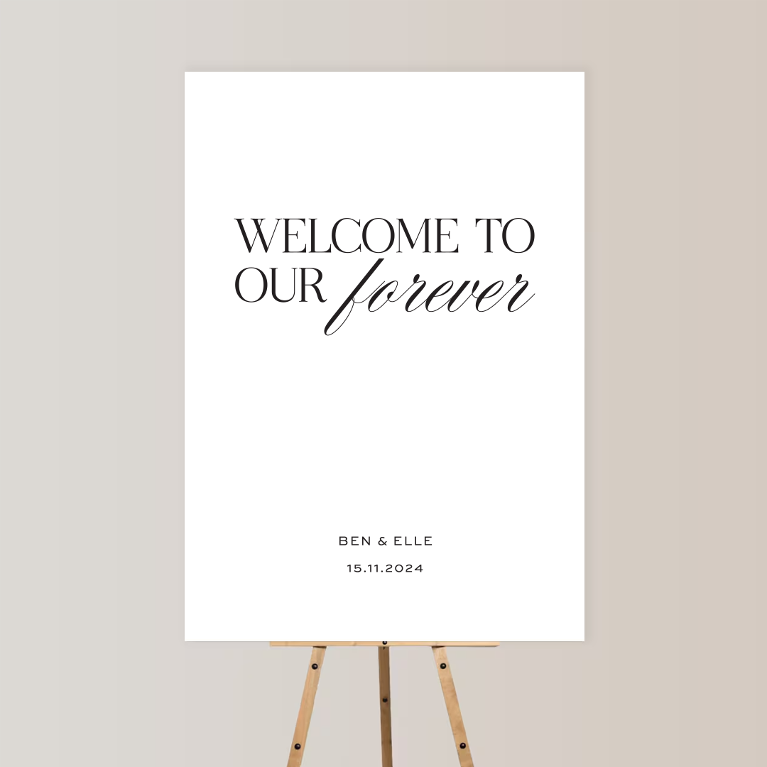 A welcome sign on an easel with the text 'Welcome to our forever,' featuring the names Ben & Elle and the date 15.11.2024.