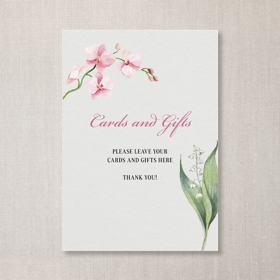 A sign with pink and white flowers at the top and bottom, reading "Cards and Gifts" in pink cursive and asking to leave cards and gifts here, with a neutral background.