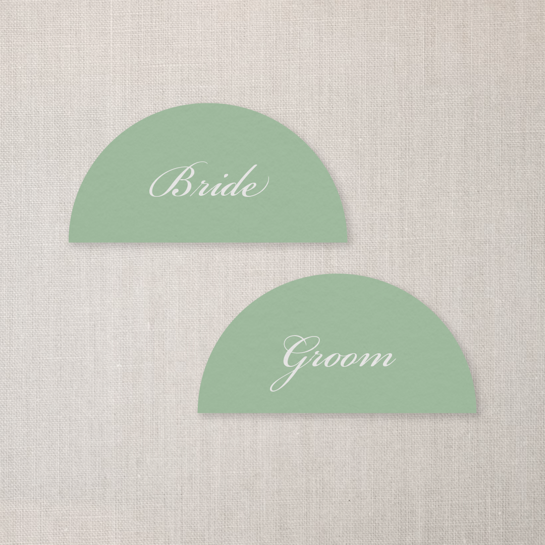 Seating chart with green half-circle labels for bride and groom on a beige fabric background.