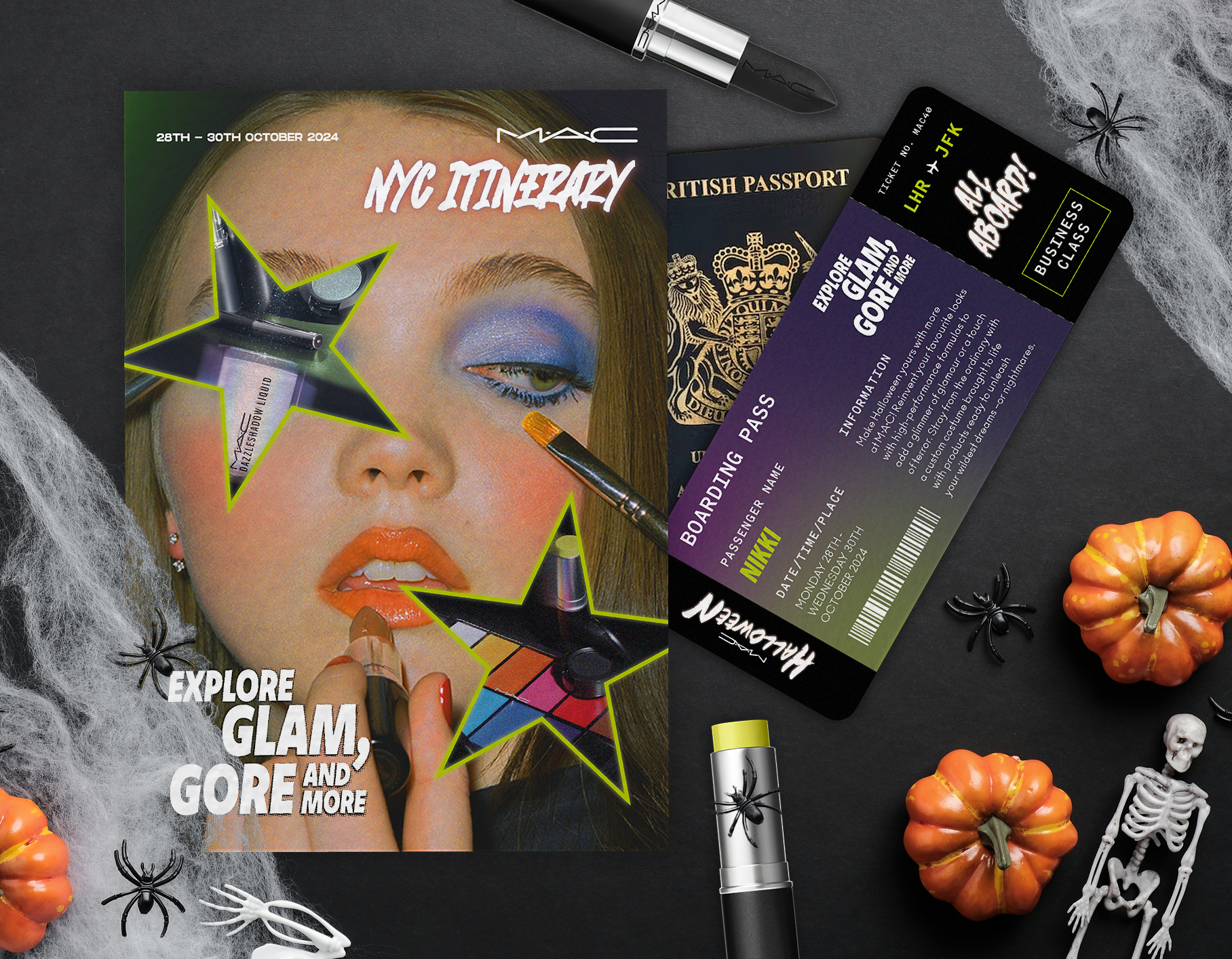 A Halloween-themed flat lay featuring makeup items, a NYC travel itinerary, a British passport, a fake boarding pass, small plastic pumpkins, plastic spiders, and a miniature skeleton on a dark surface.