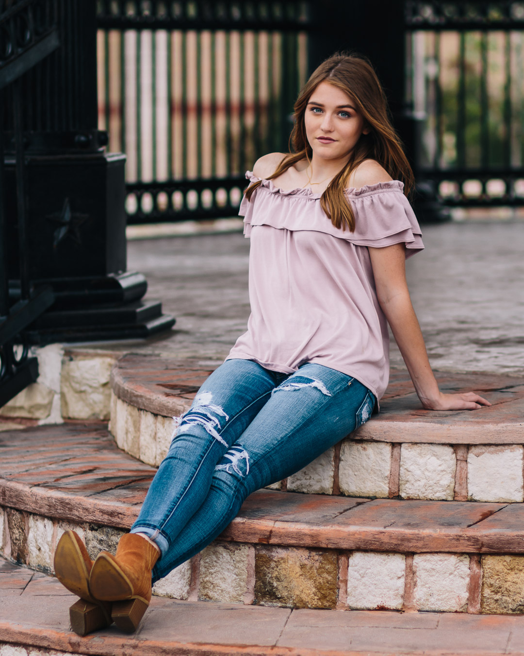 Senior girl in jeans outfit under gazebo