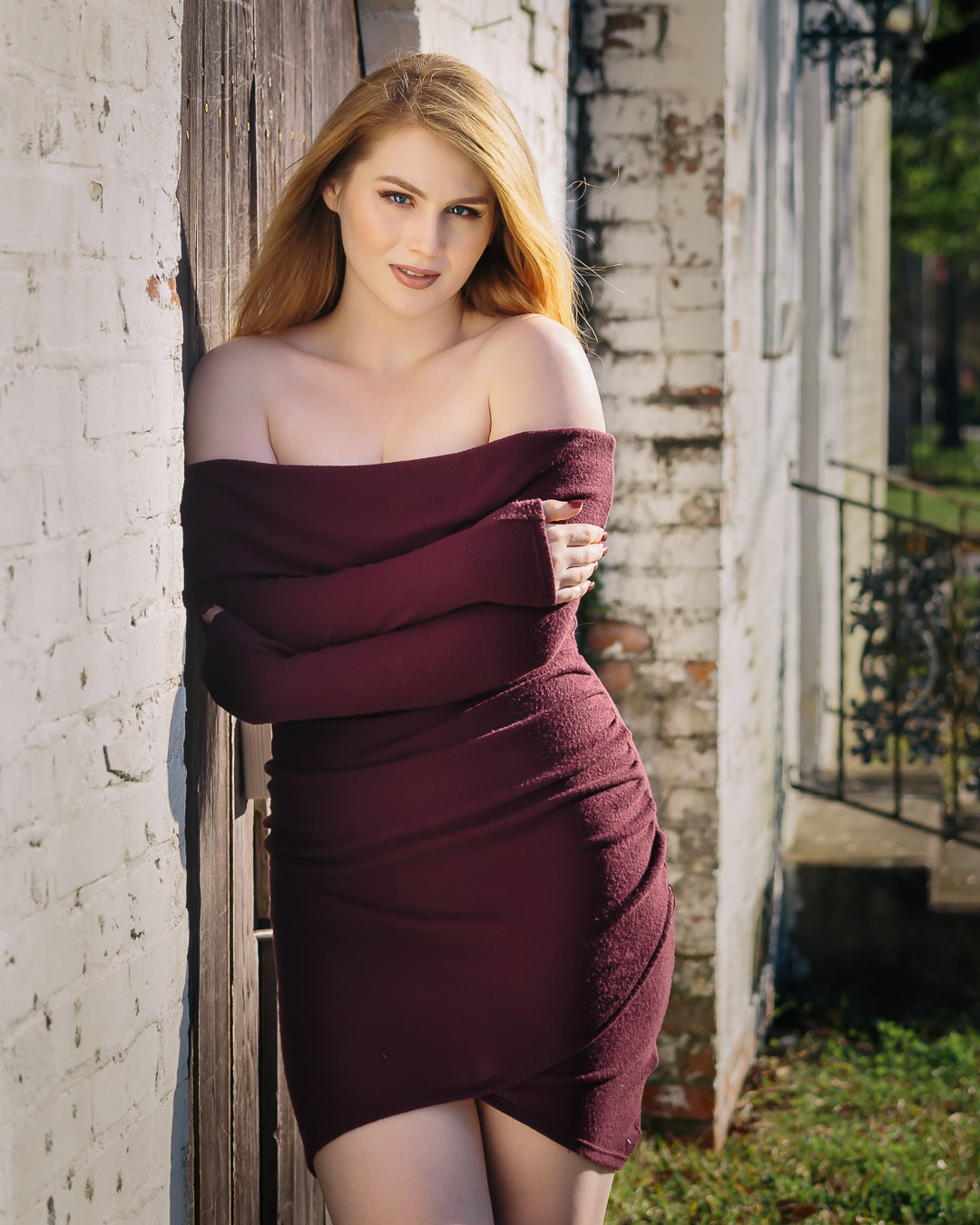 Senior girl in maroon dress off of shoulders in small town