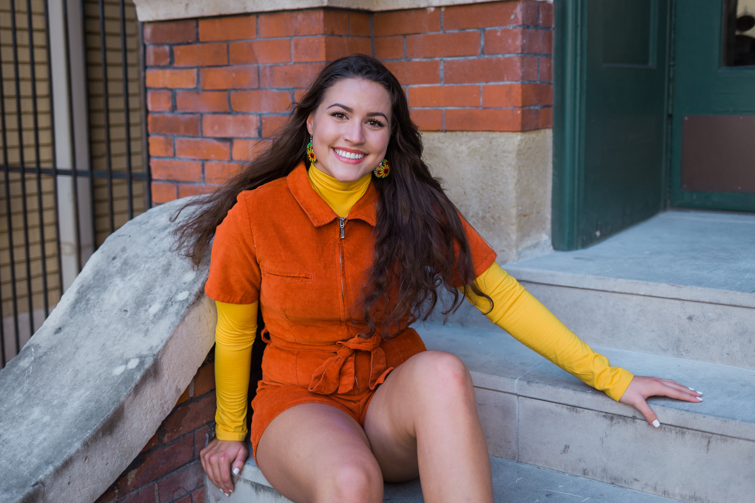 Senior girl with wavy hair in vintage orange and yellow outfit