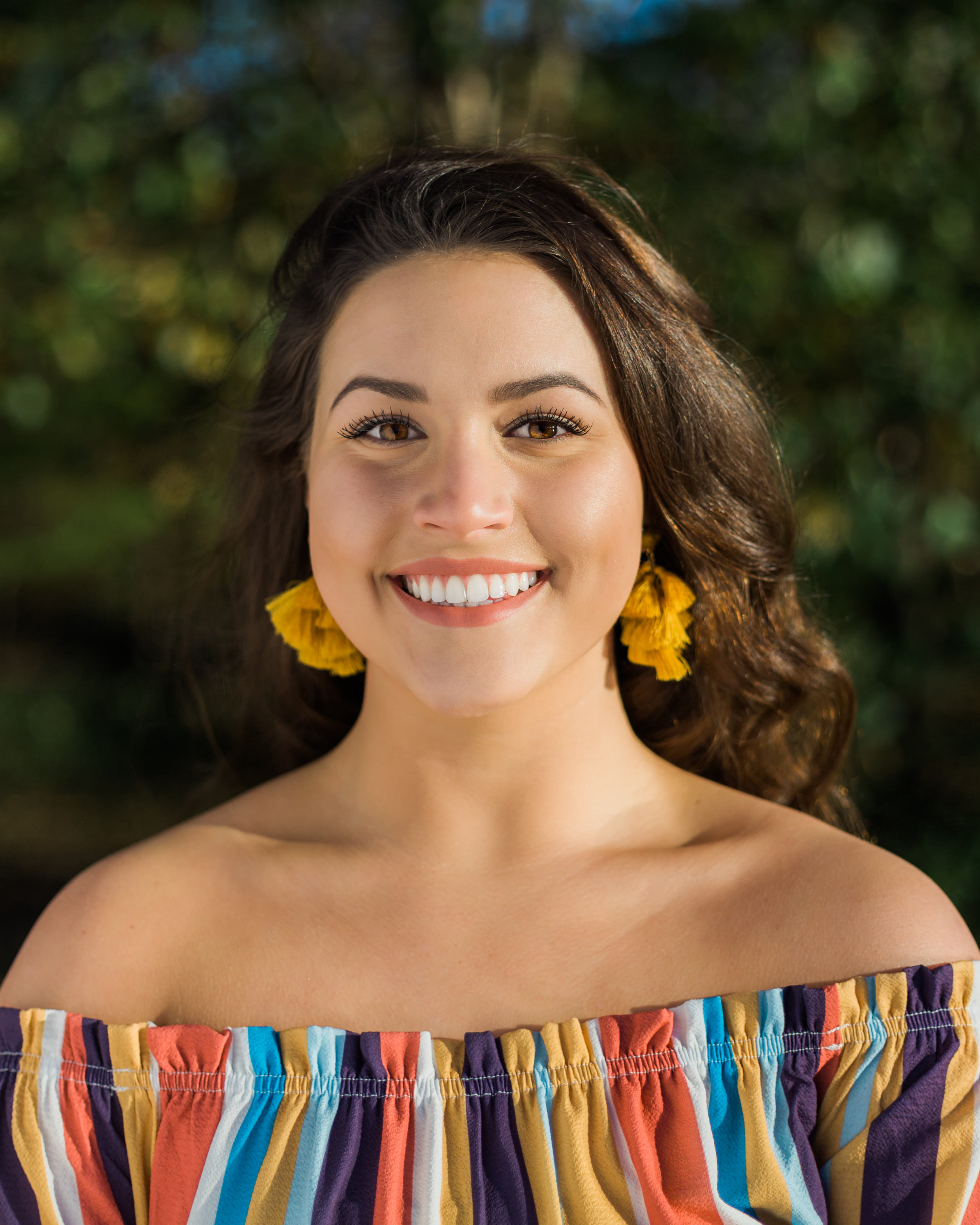 Beautiful senior with colored striped shirt and yellow earrings