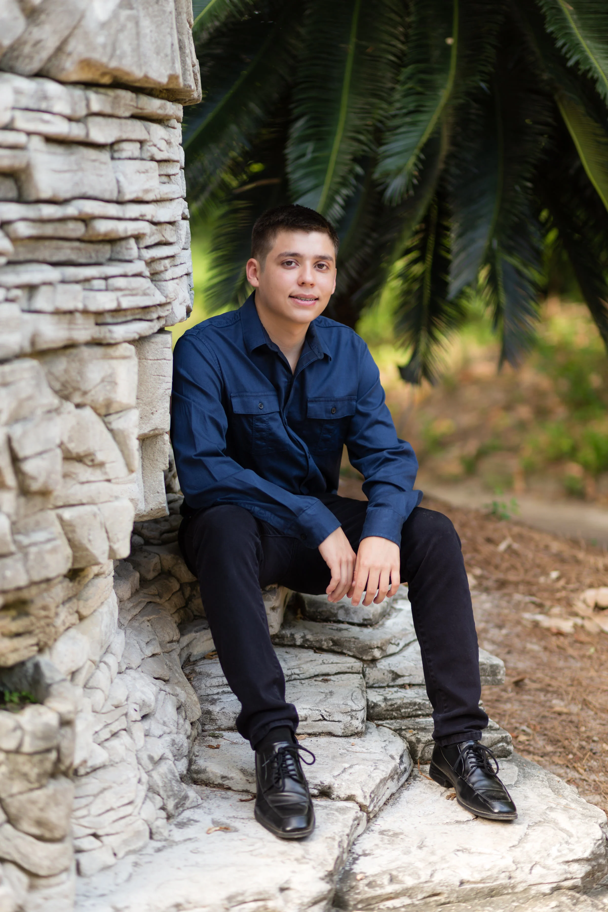 Senior male sitting on rocks in garden