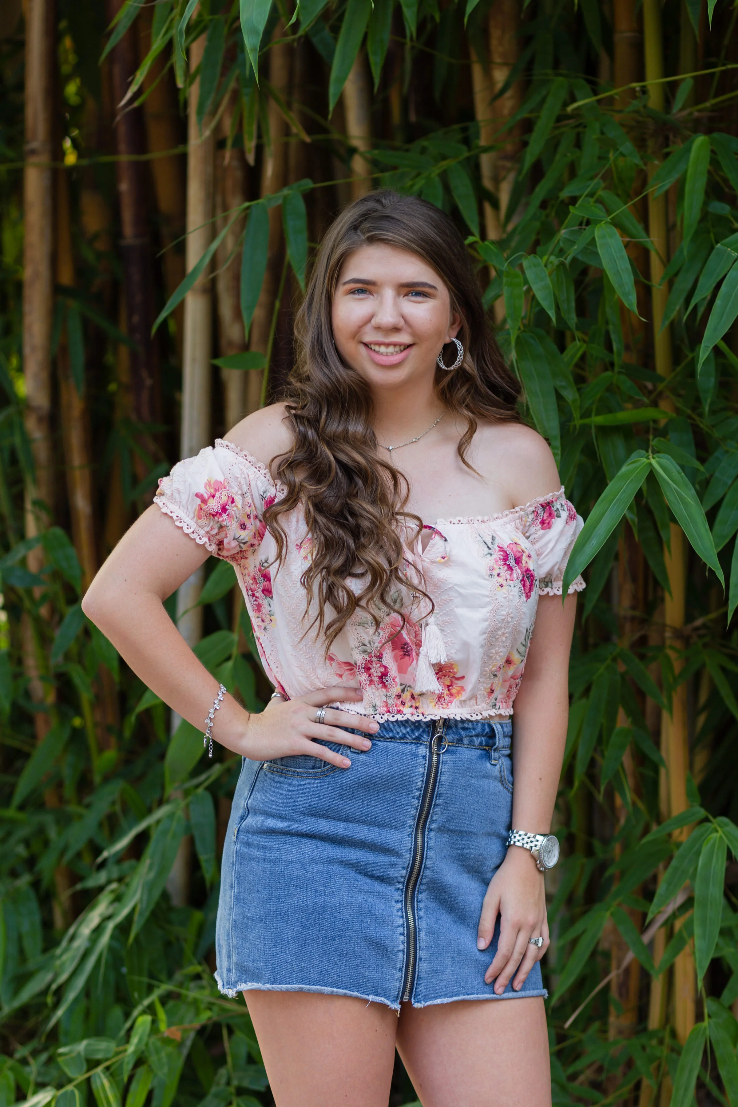 Senior girl with denim skirt in front of bamboo