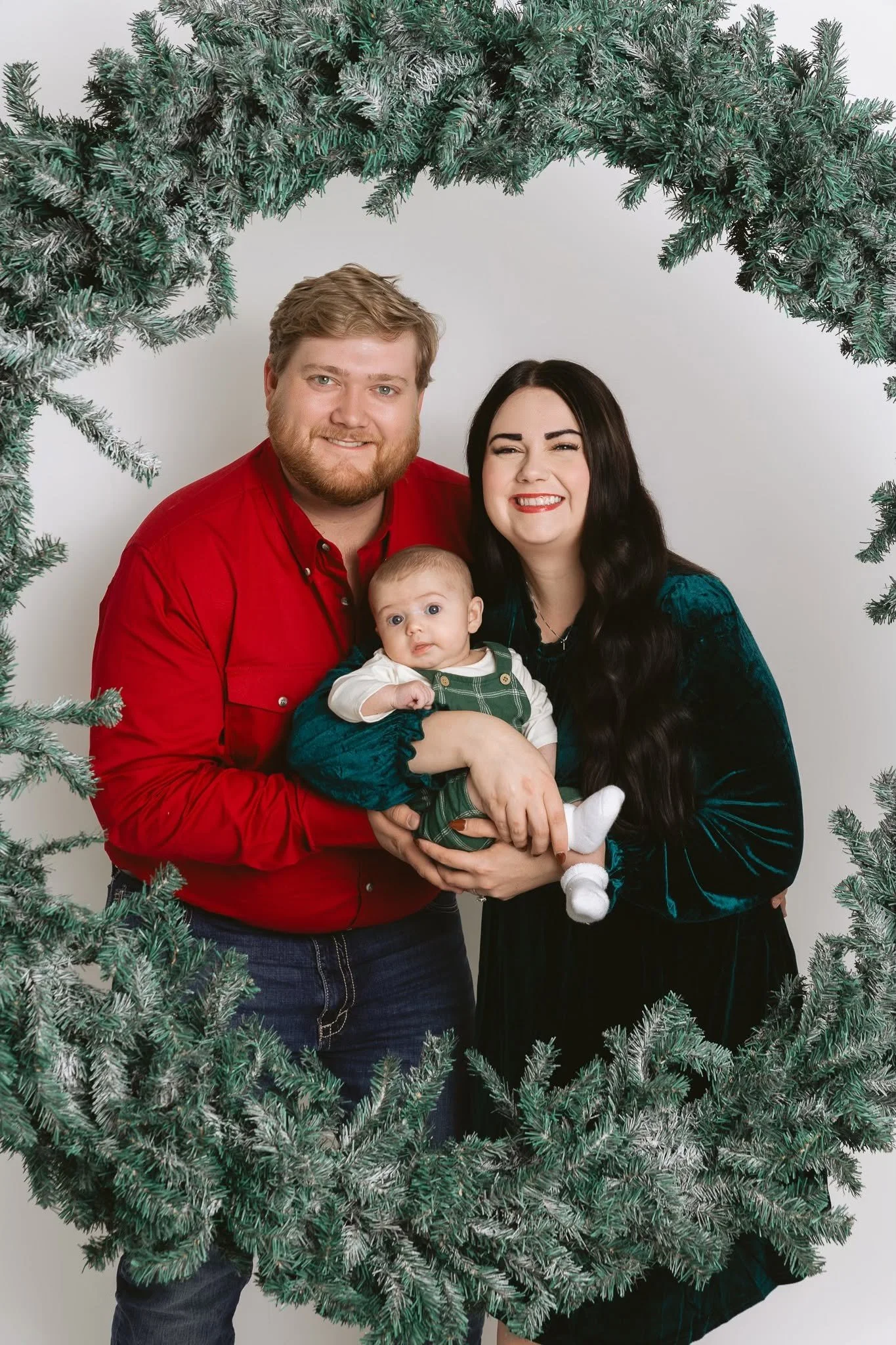 christmas couple with infant wreath portrait