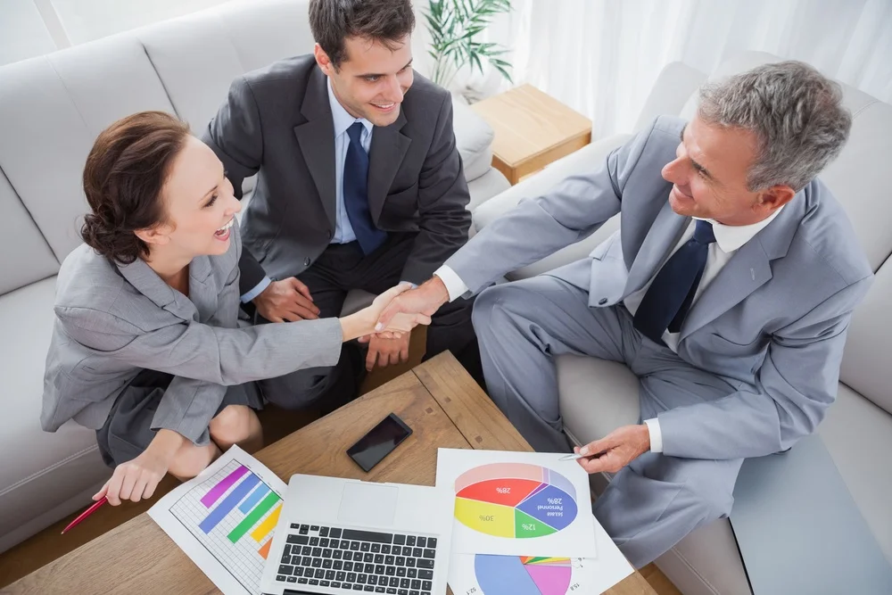 Business people shaking hands while working in cosy meeting room.jpeg