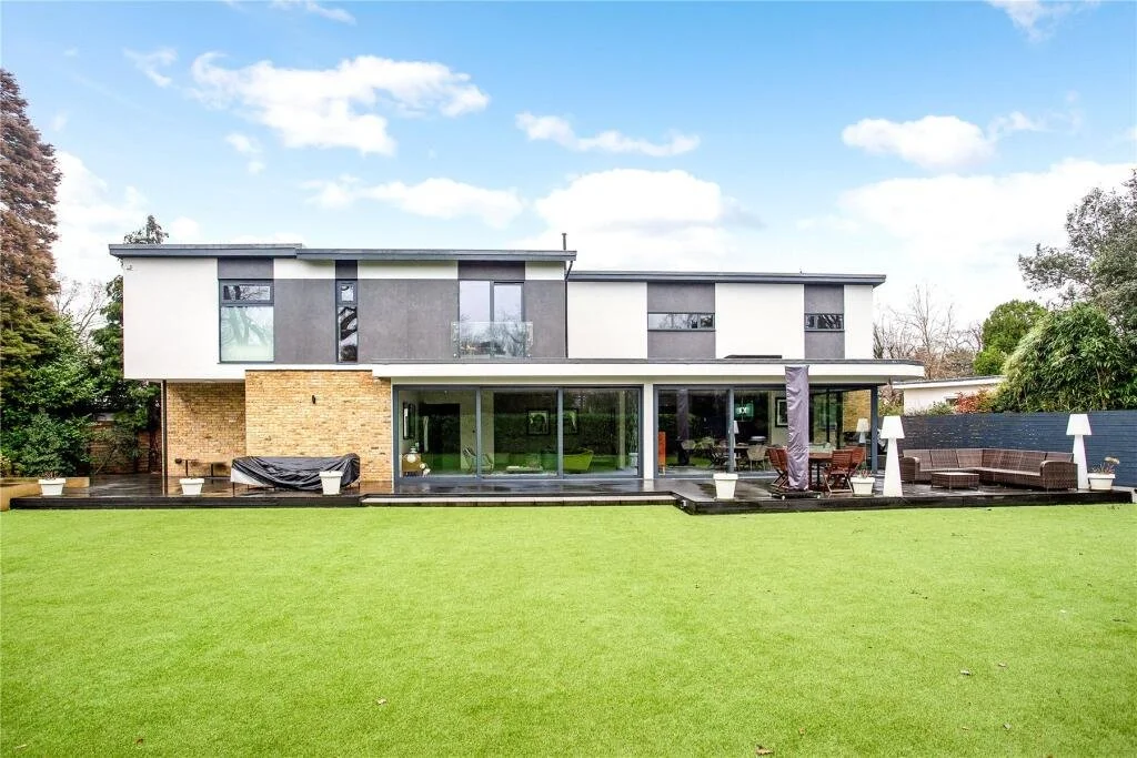 Rear elevation of the detached family residence overlooking mature landscaped gardens with a sunny westerly aspect in the Burwood Park Estate, Walton-on-Thames.