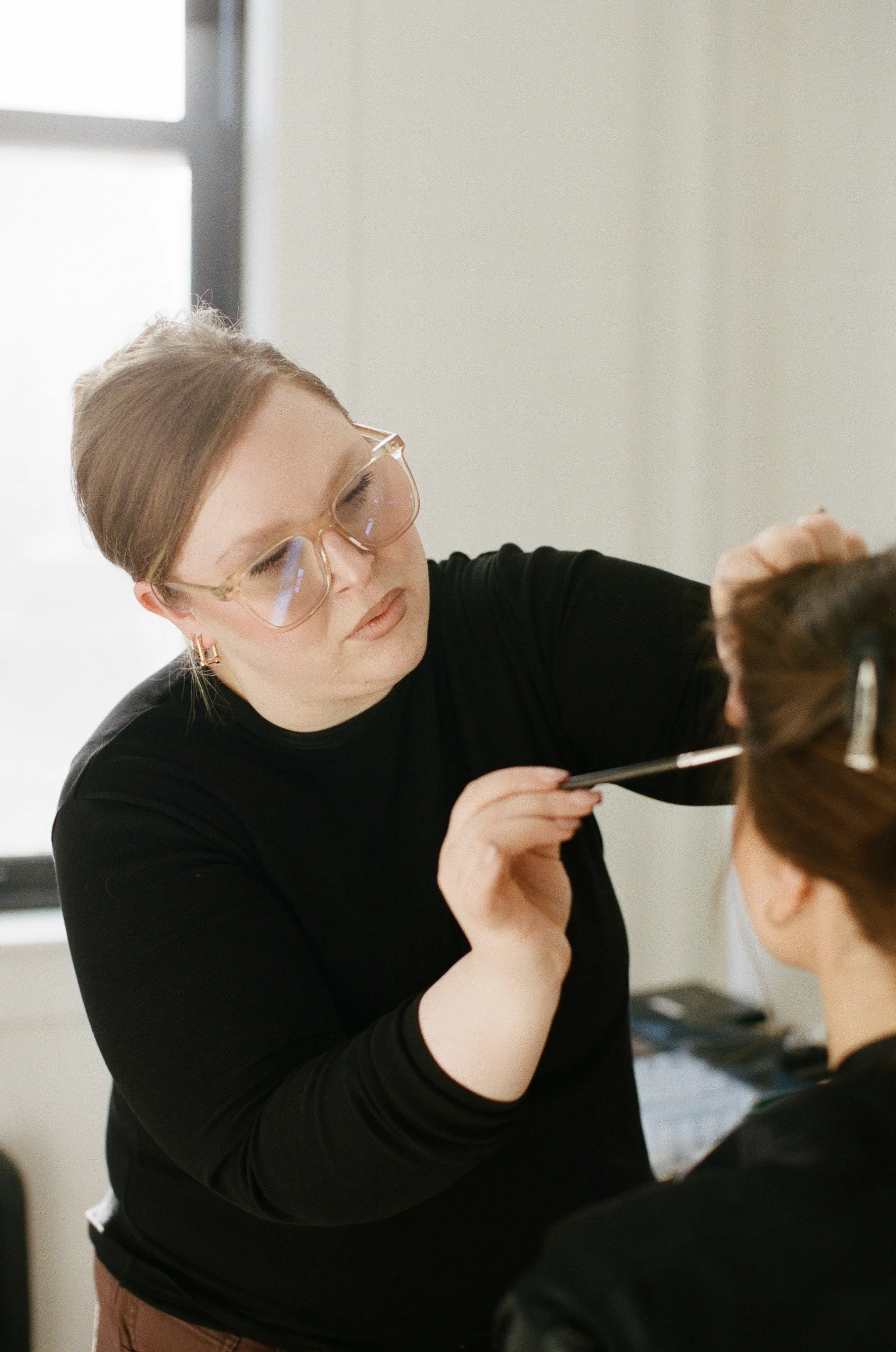 Makeup artist applying luxury bridal makeup during the bride's wedding morning preparations.