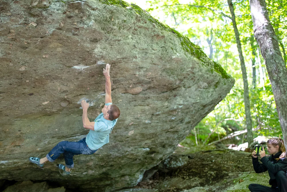 Alexander Tighe climbing Parliers Problem (V8) on the AVP Boulder. Photo by Jeff Nicholls.