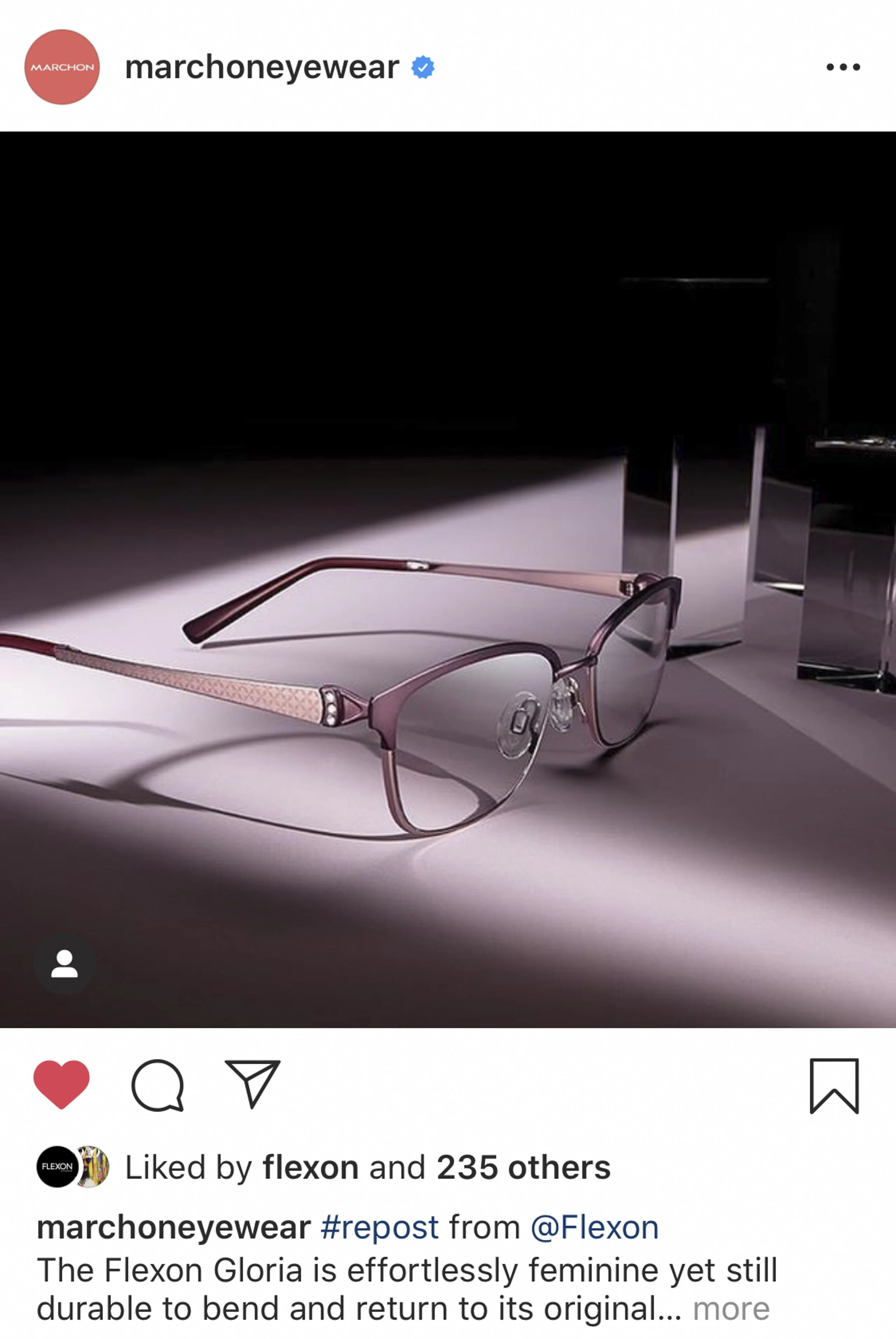 Pink and purple fashion eyeglasses with metal frame and tinted lenses resting on a surface with dramatic lighting and shadow.